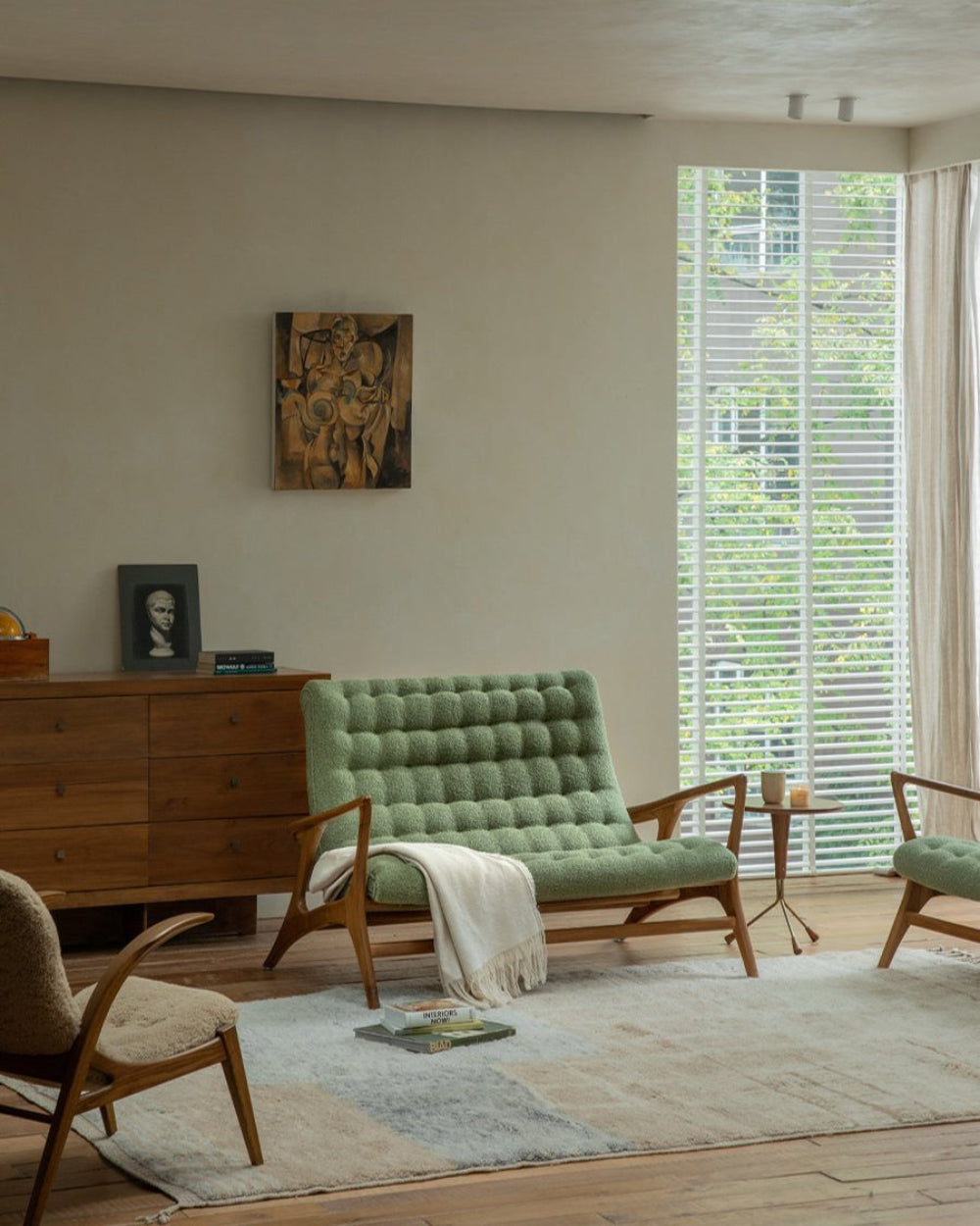 Green bouclé Kagan Loveseat with teak frame in a cozy living room; Mid-century modern design; Comfortable design