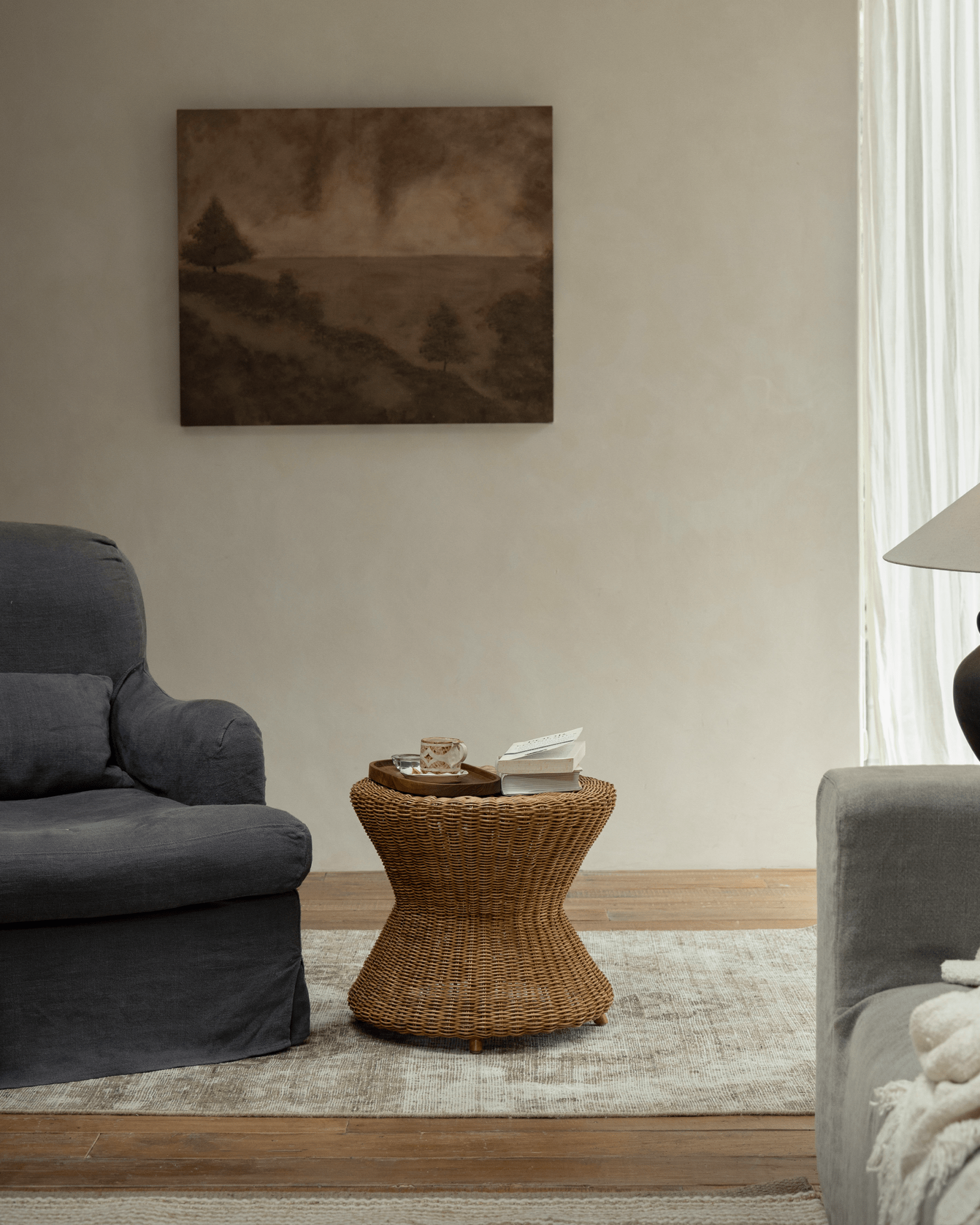 Bongo Rattan Side Table with hourglass shape on tripod metal base, woven Indonesian Manau rattan.