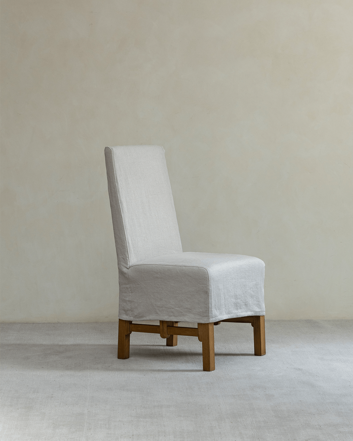 Feast Dining Chair with light beige linen slipcover and wooden frame