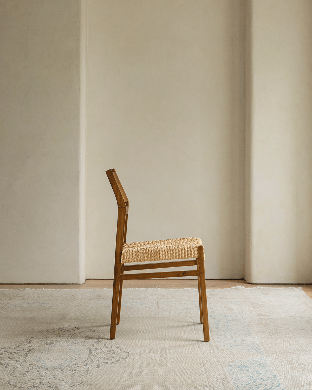 Beam Chair with teak wood frame and woven seat, showcasing minimalist design and natural warmth