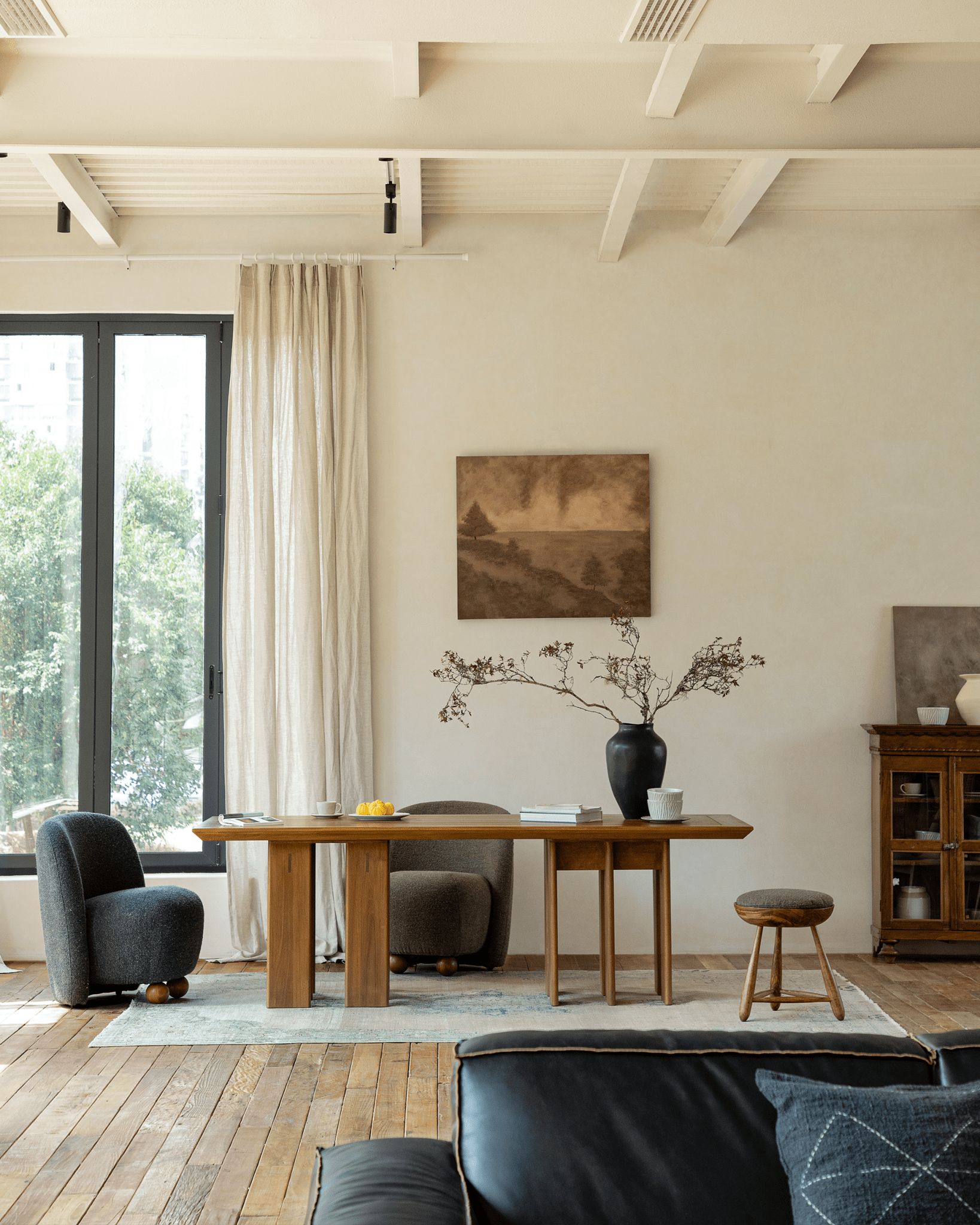 Titan Teak Dining Table in modern dining room with teak chairs, wood floor and large window.