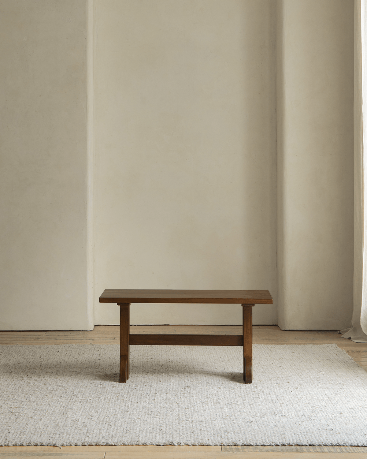 Hoof Side Table in dark nanmu wood, retro design, featured on a neutral rug and room.