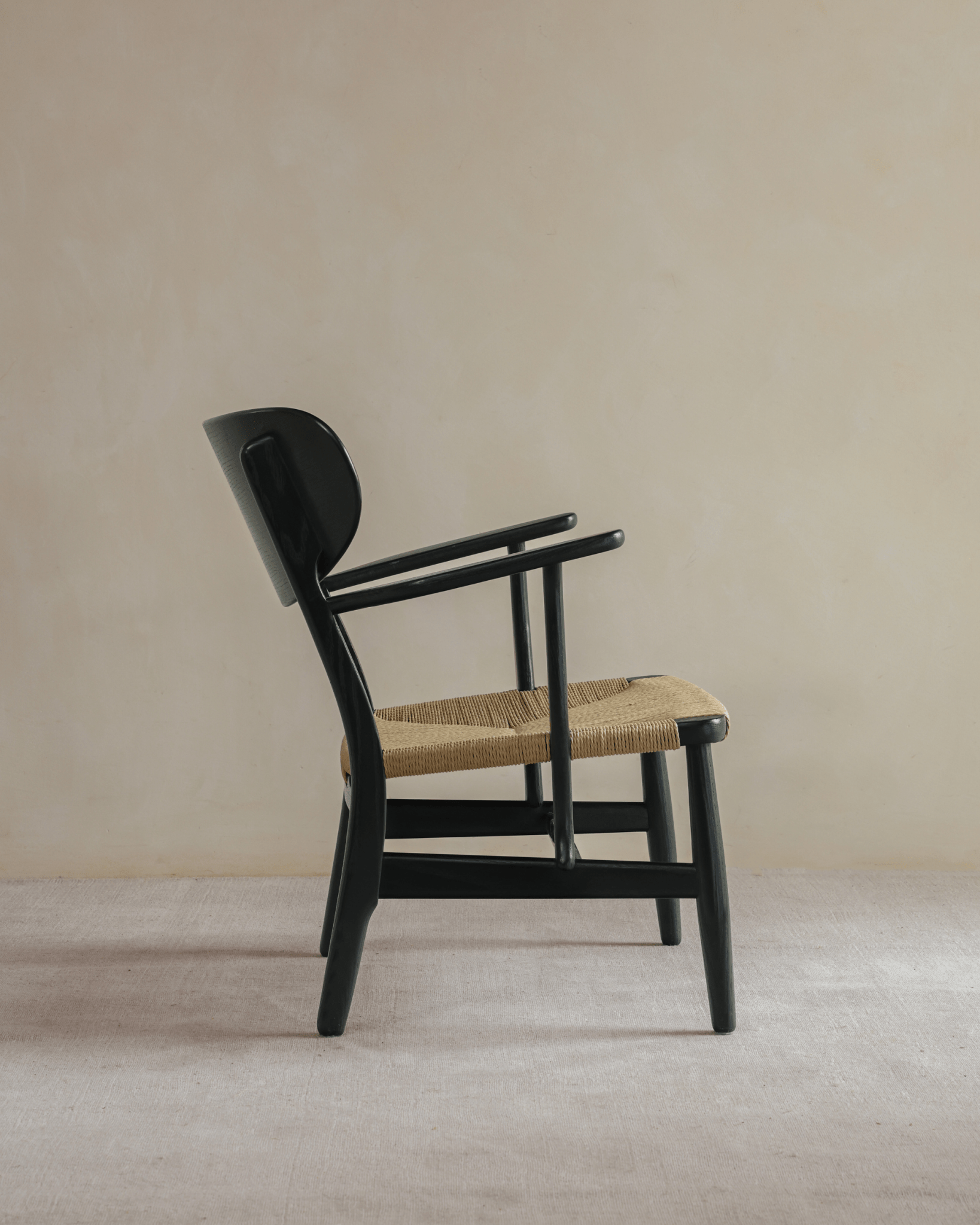 CH22 Lounge Chair in black with paper cord seat, Scandinavian design icon for modern interior