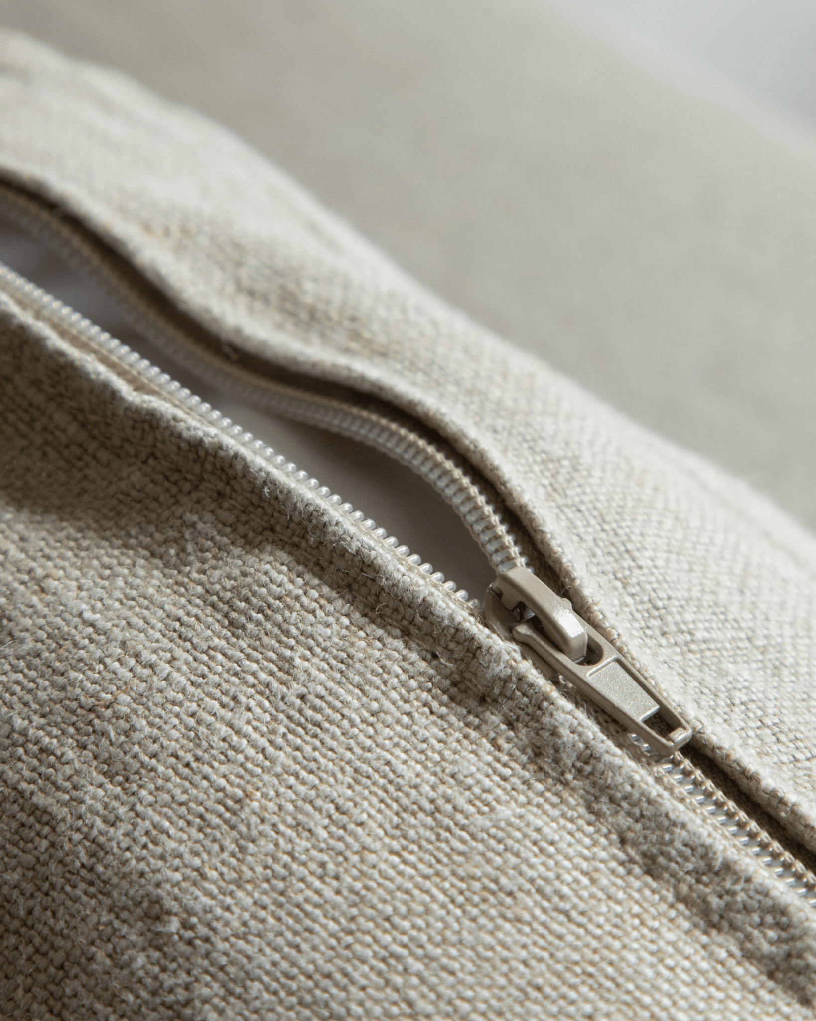 Nola Sofa detail: Close-up of natural linen fabric and zipper, showing quality and breathable material.