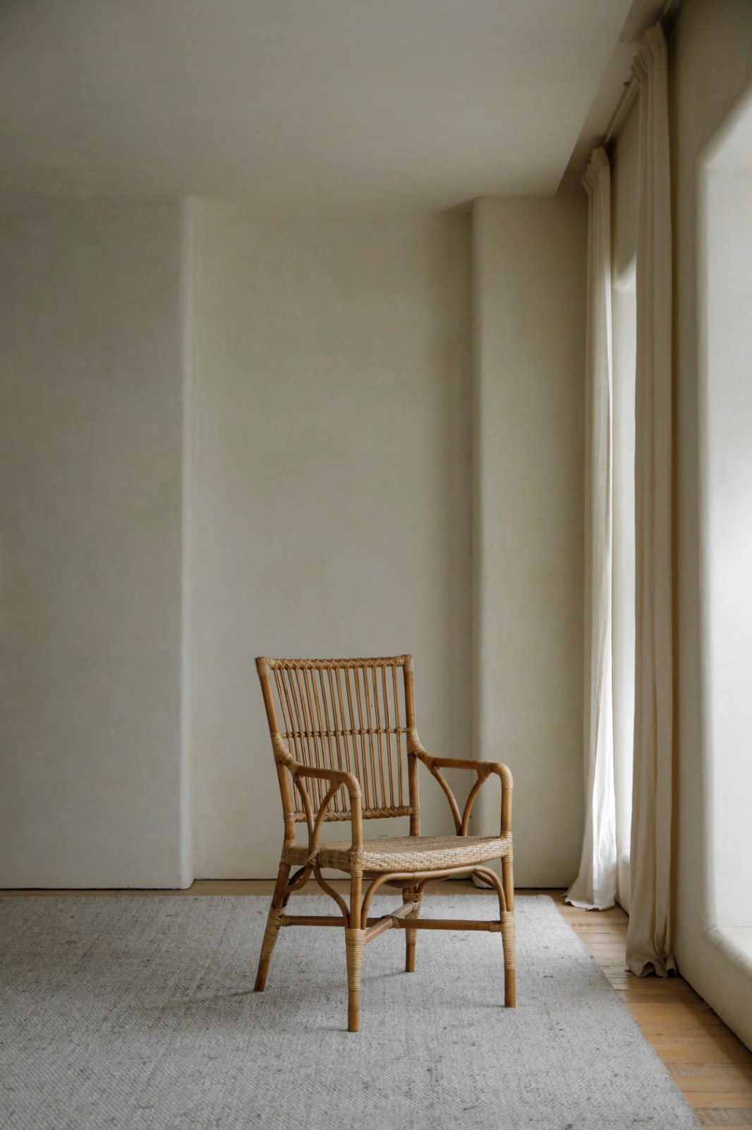 Axis Chair - Indonesian rattan armchair in a neutral interior setting, rattan chair with armrests
