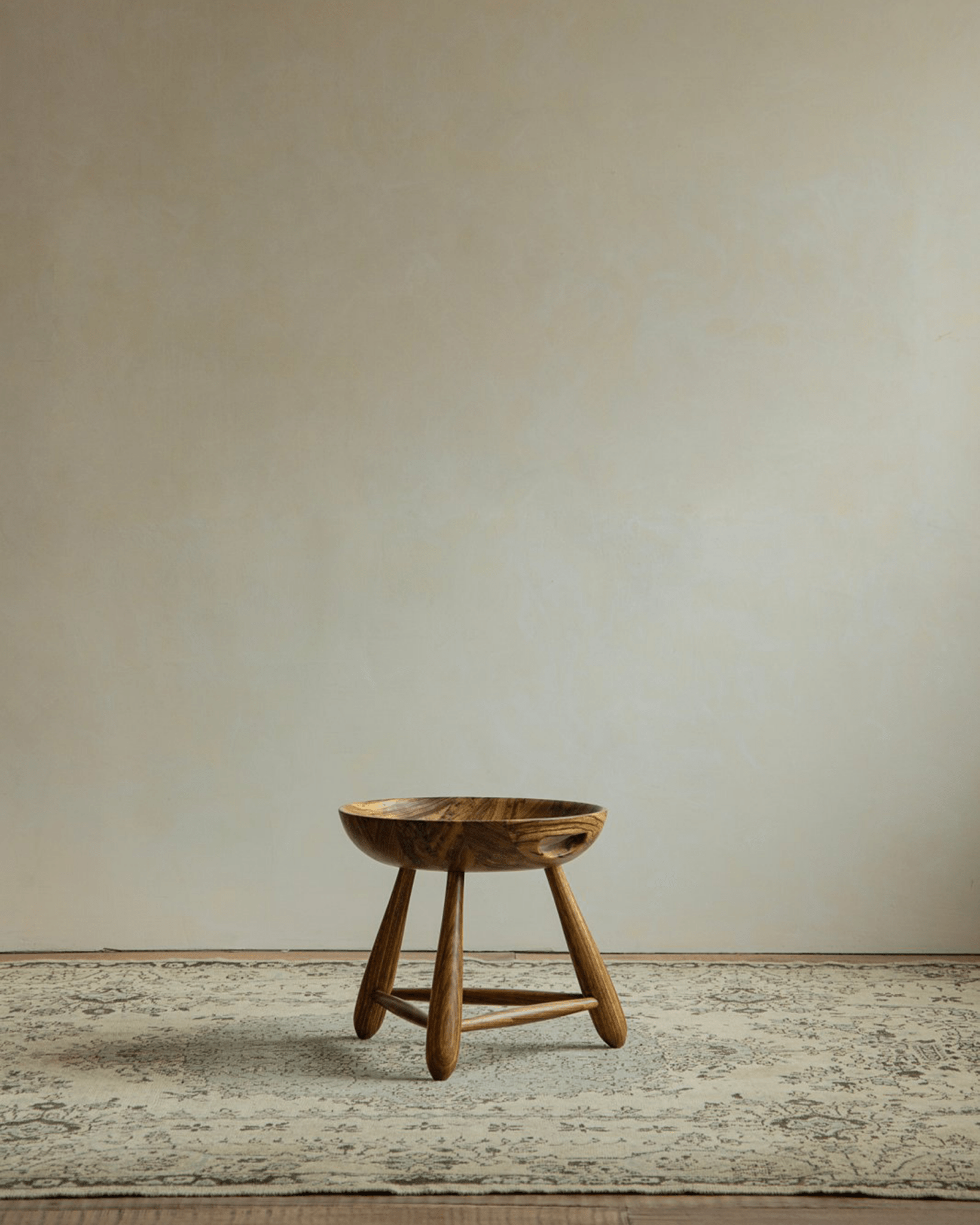 Zebrawood Mocho stool with carved seat, natural wood grain and tripod legs. Modern design.