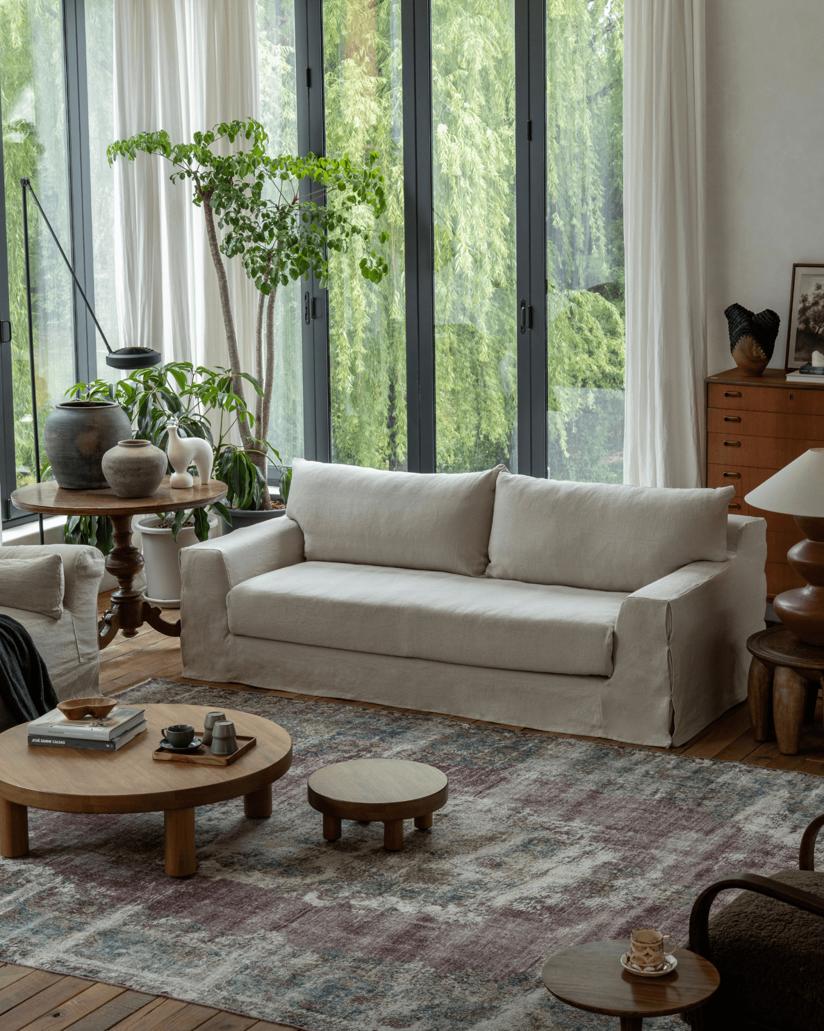 Guni Linen Sofa in beige linen fabric. Cozy living room setting with wooden furniture and natural textures