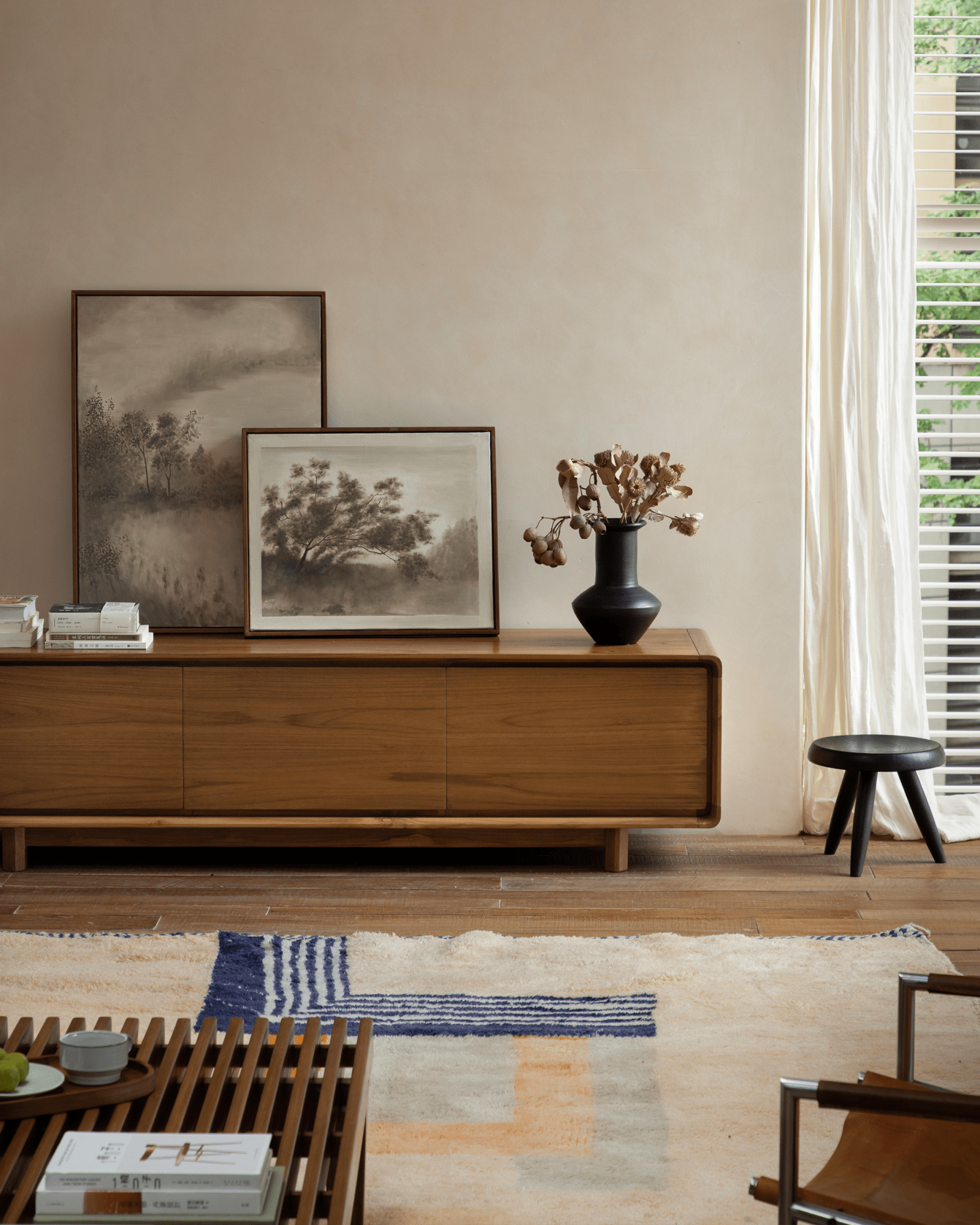 NO.34 Media Console in a modern living room, with wooden cabinet, artwork, decorative items, and rug.
