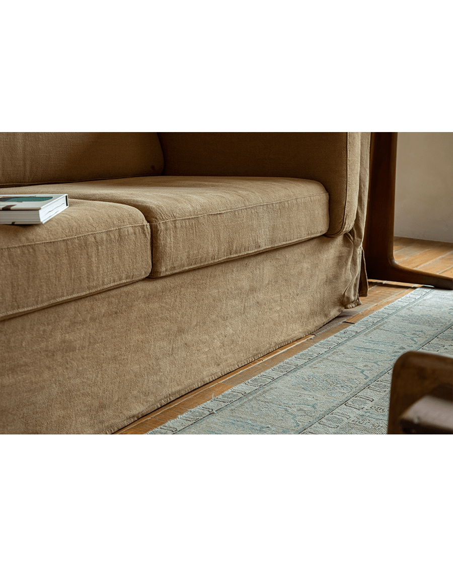 Tan linen Skirt Sofa detail. Modern design with breathable fabric and skirt. Ideal for a comfortable and peaceful space.
