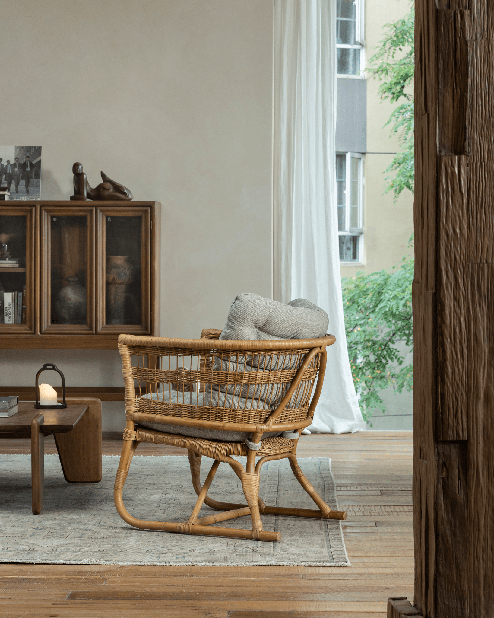 Helian Rattan Chair in cozy interior setting, natural rattan frame, gray silk cushion, stylish design