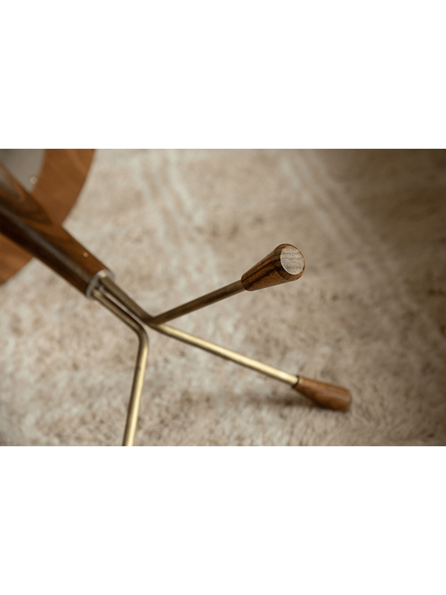 Larsson Side Table detail: Brass legs with wooden accents, close-up view, aged brass finish.