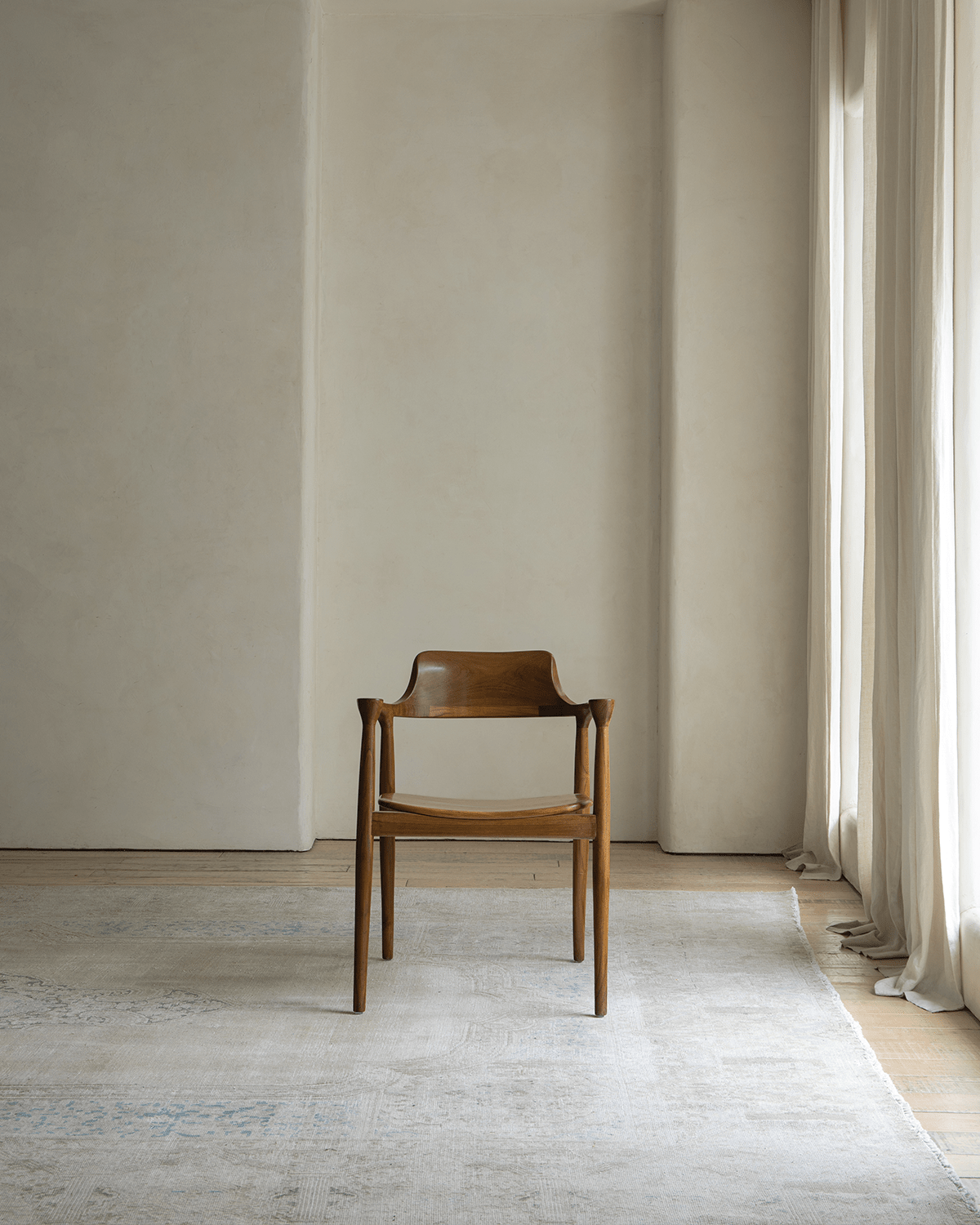Hiroshima Chair in solid wood, elegant design in a modern living space, showcasing curved backrest and armrests