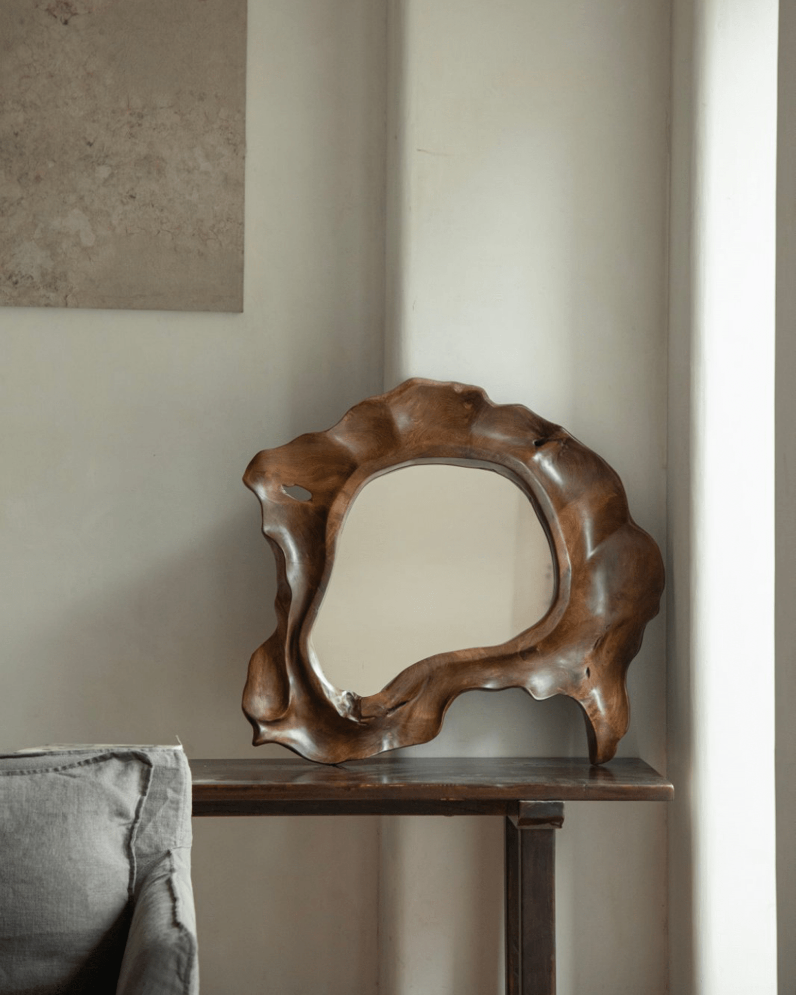 Organic Wood Arbor Mirror with natural shape on dark wood table, modern interior decor