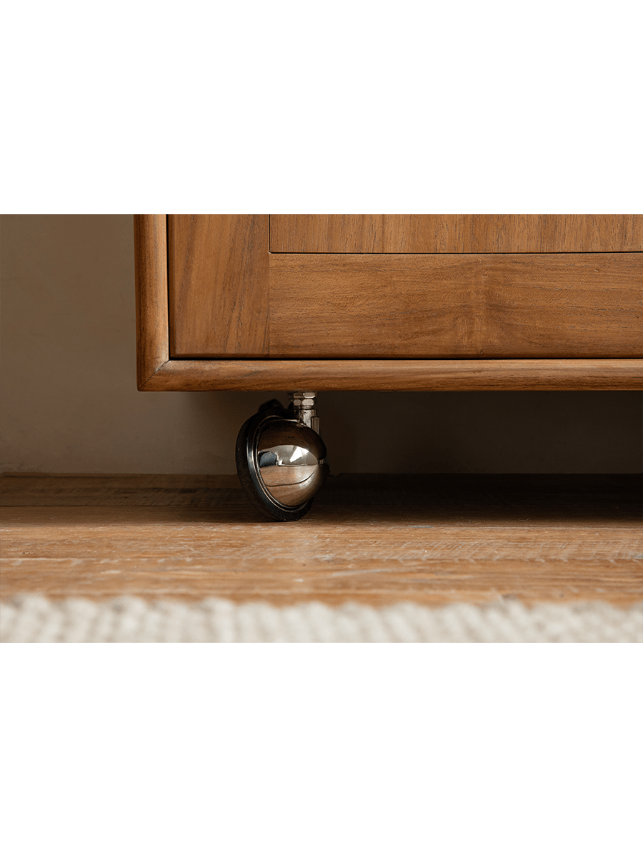 Lidi Display Cabinet detail, showing teak wood cabinet corner and universal wheel for mobility
