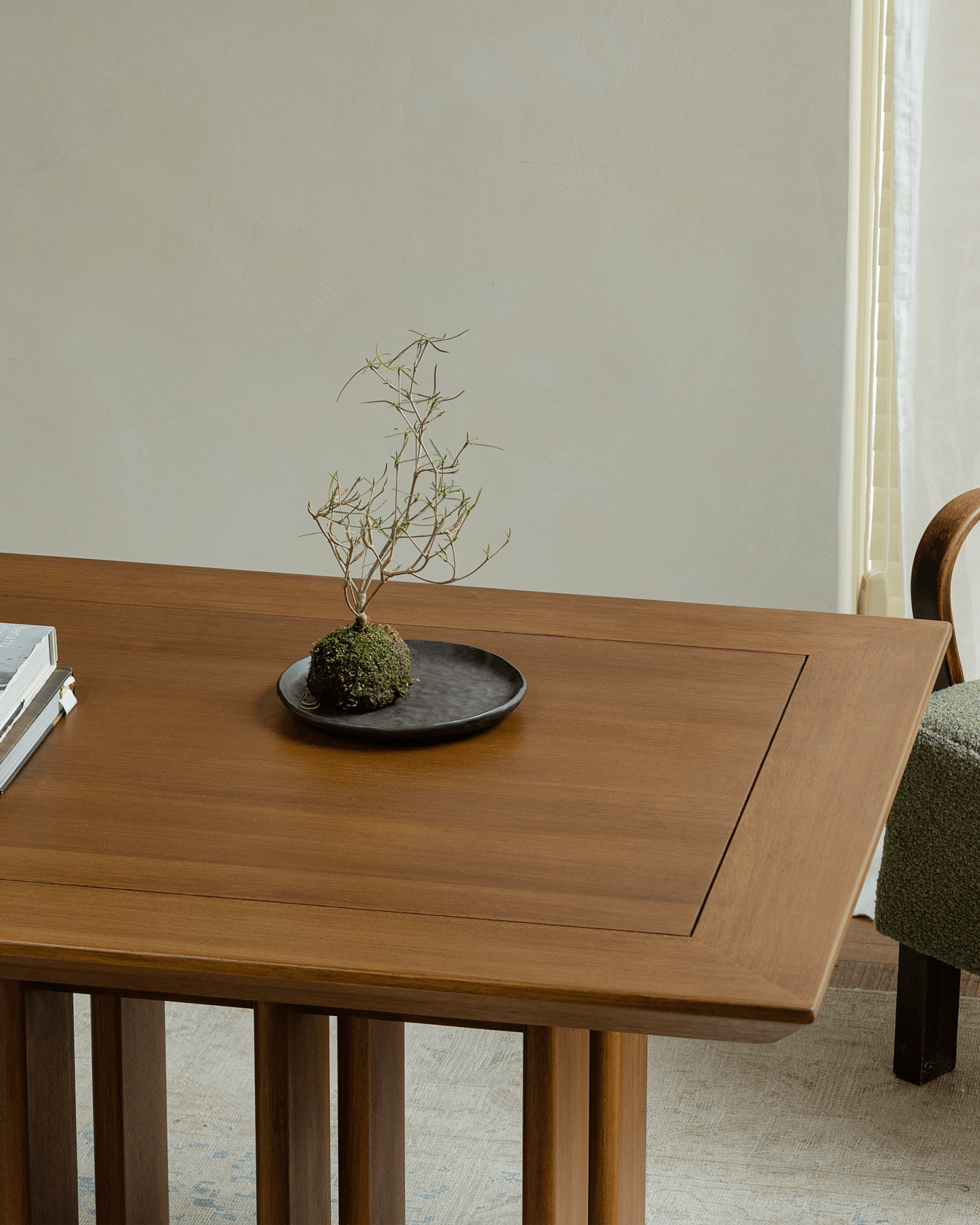 Titan Teak Dining Table detail with decor on tabletop, teak wood, and multi-leg design