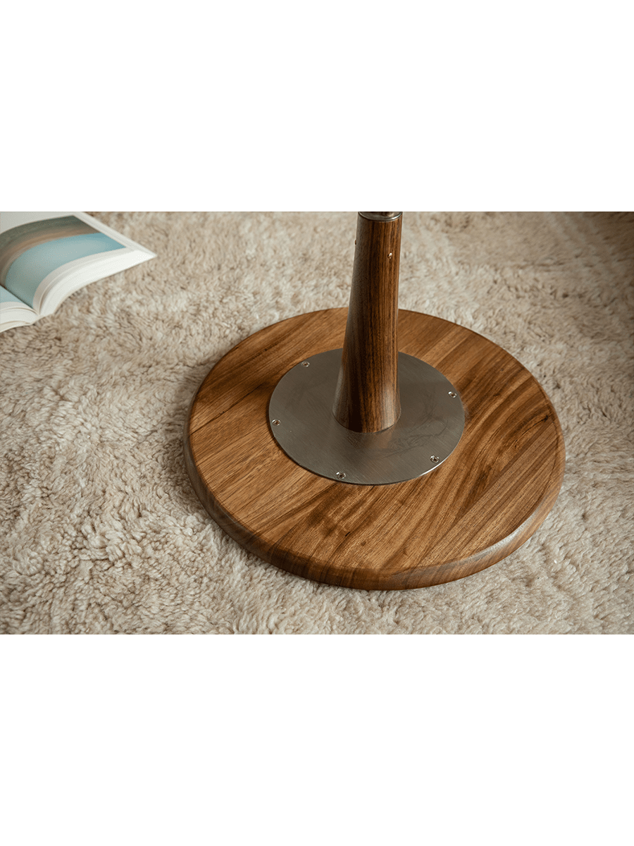 Larsson Side Table detail: Wood top with metal and wooden leg base.