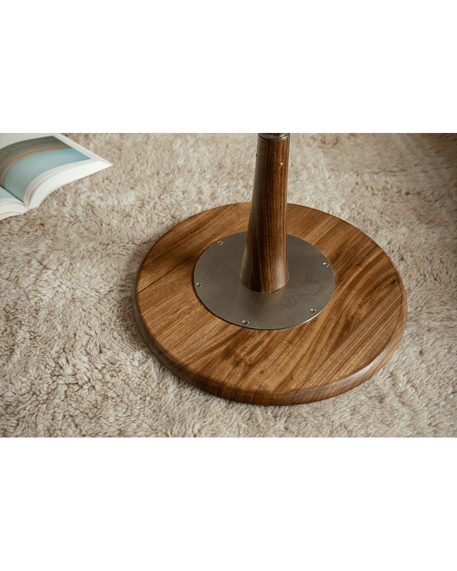 Larsson Side Table detail: Wood top with metal and wooden leg base.