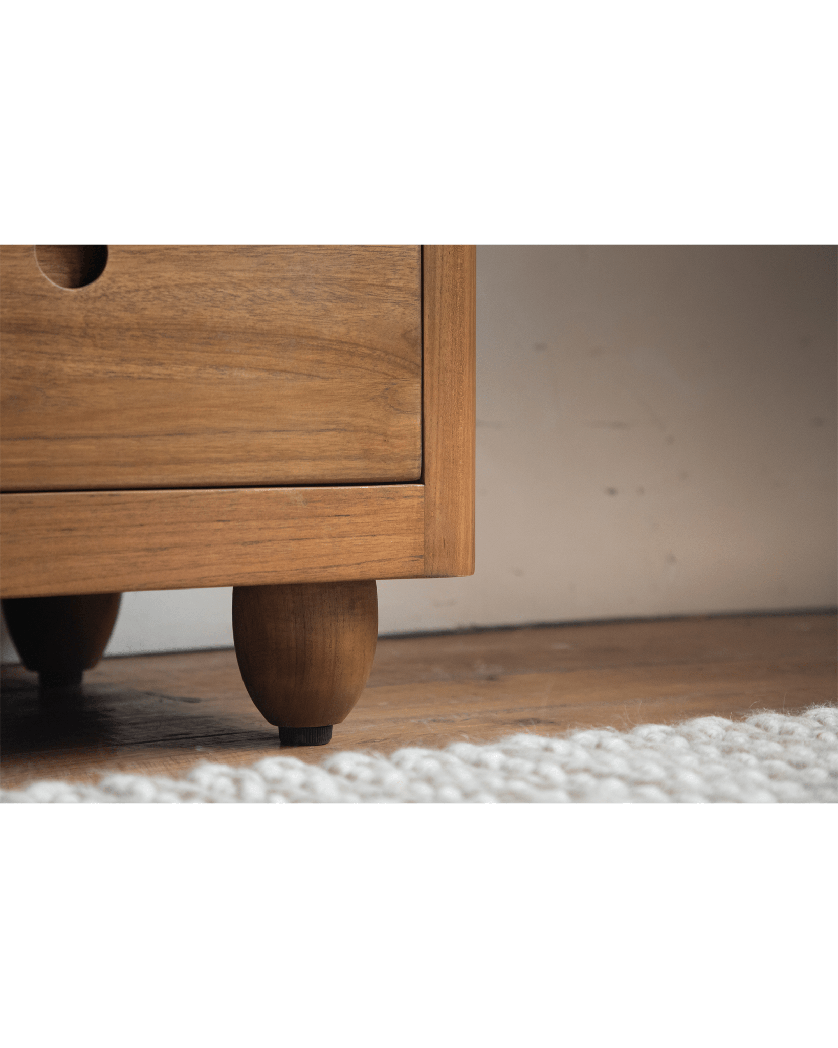 Reve Teak Bookcase drawer and leg detail, showing the wood grain and unique leg design in teak.