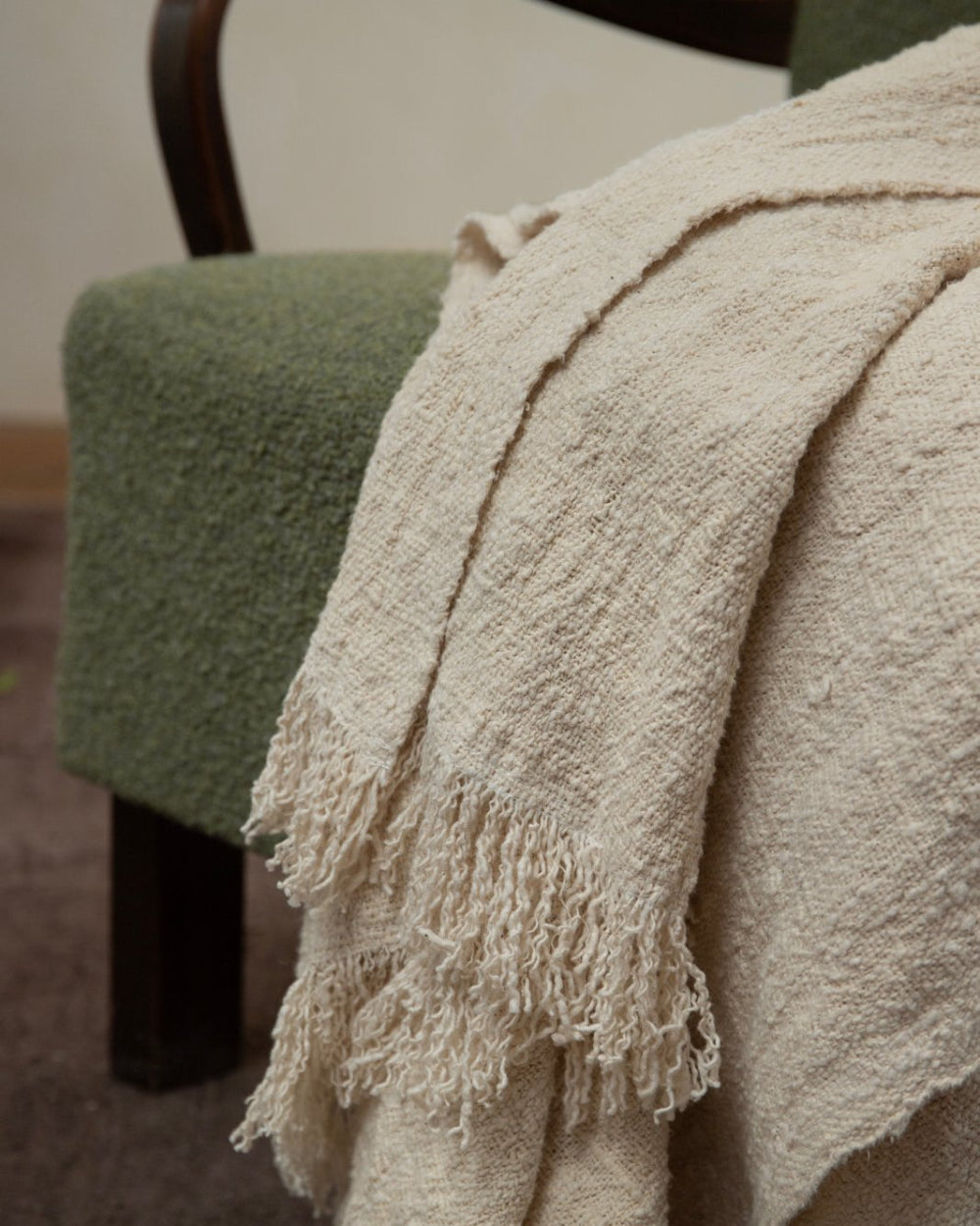 Cream cotton blanket with fringe on green armchair; Cotton blanket for home decor