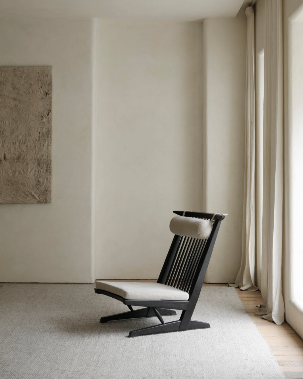 George Lounge Chair in black teak wood, light cushion, and modern living room design