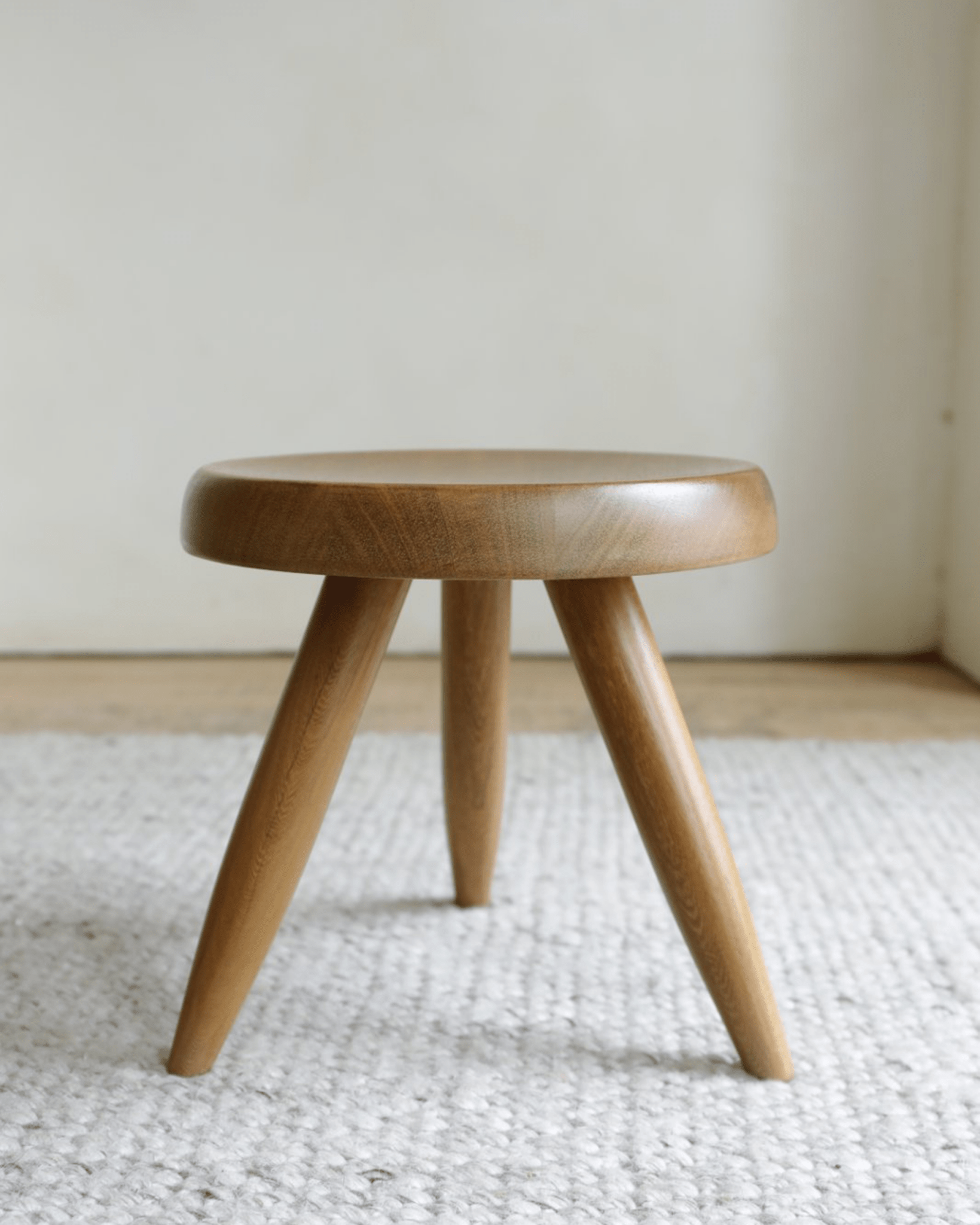 Natural wood French stool with round seat and three legs, perfect for modern home decor