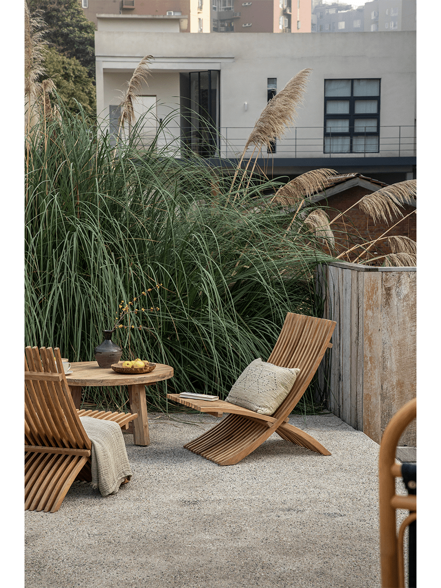 Oly Lounge Chair in outdoor setting. Wooden slatted design, portable, ergonomic comfort for outdoor relaxation and style.