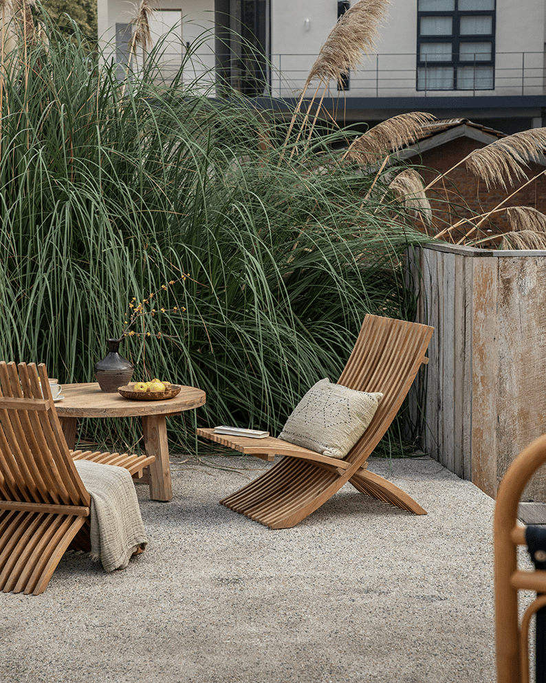 Oly Lounge Chair in outdoor setting. Wooden slatted design, portable, ergonomic comfort for outdoor relaxation and style.