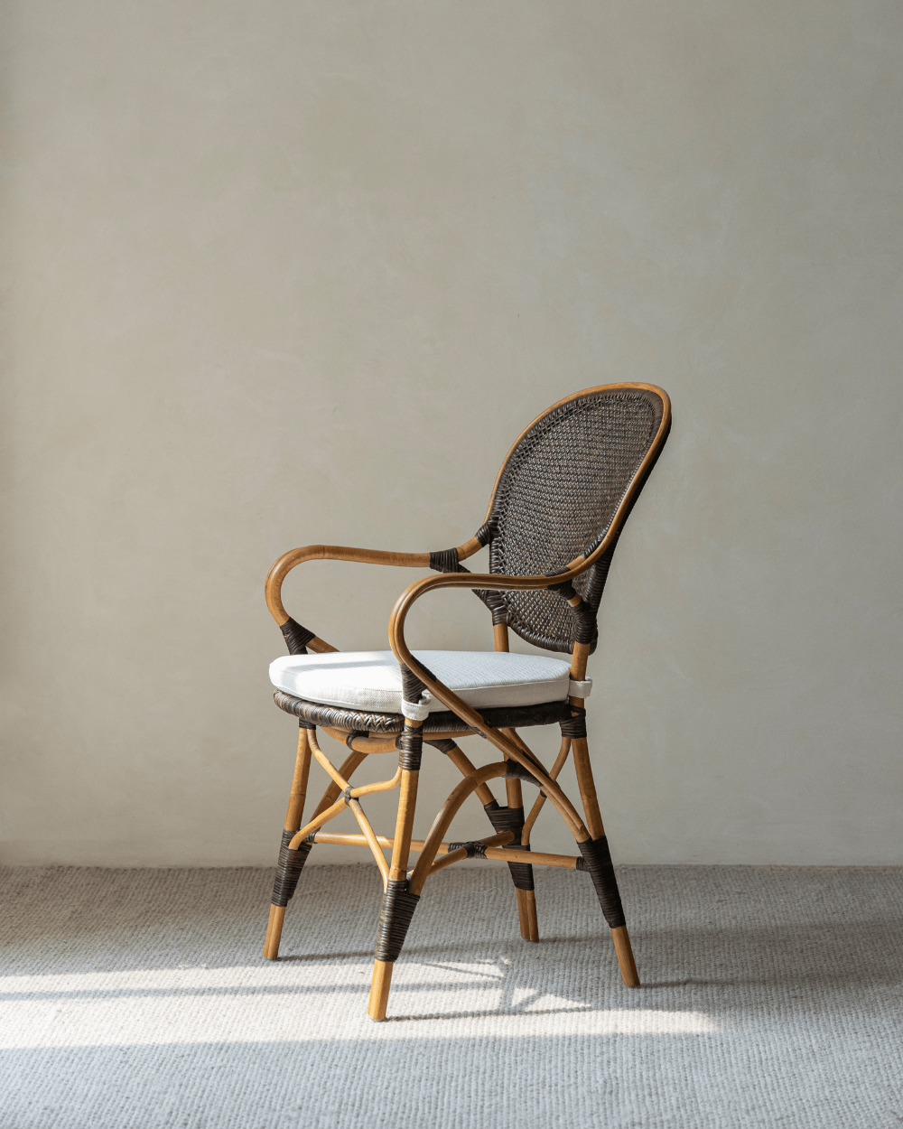 Areca Rattan Chair with handwoven backrest and armrests, white cushion, natural comfort design