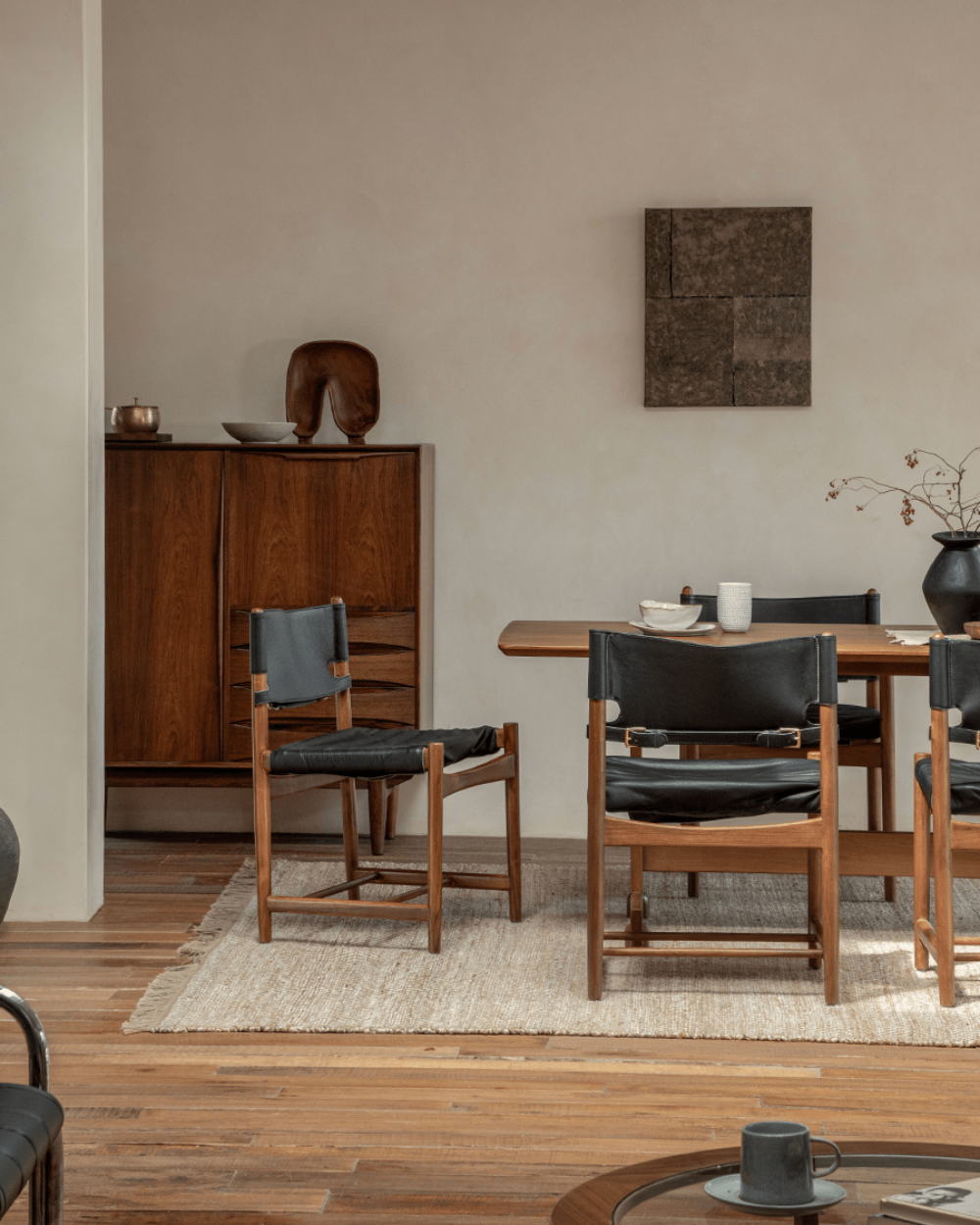 Spanish Dining Chair with black leather seat and teak wood frame in a modern dining room setting