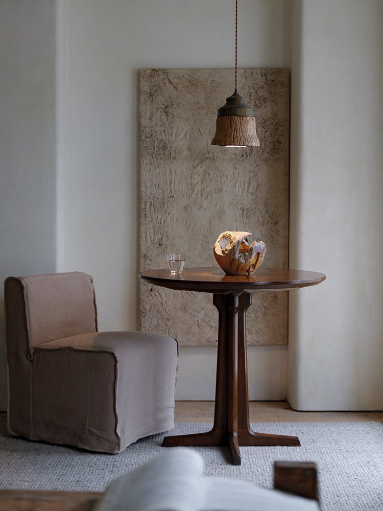 Round X Table with chair, pendant lamp, and decor in an elegant room setting