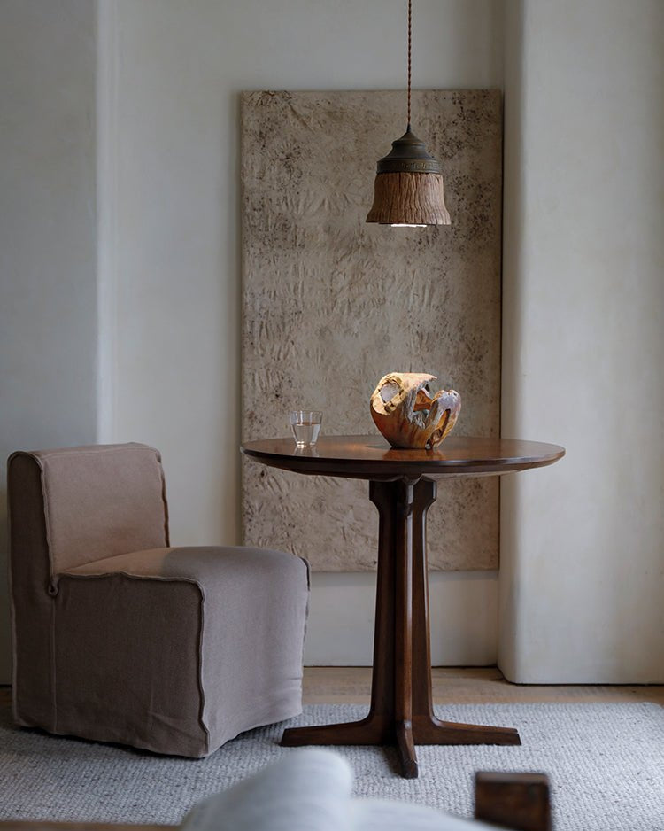 Round X Table with chair, pendant lamp, and decor in an elegant room setting
