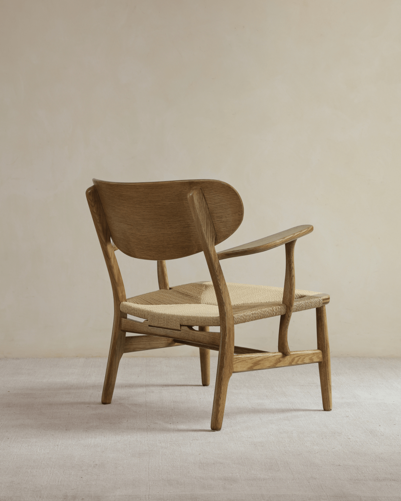 CH22 Lounge Chair with oak frame and paper cord seat, Scandinavian design icon for modern interiors