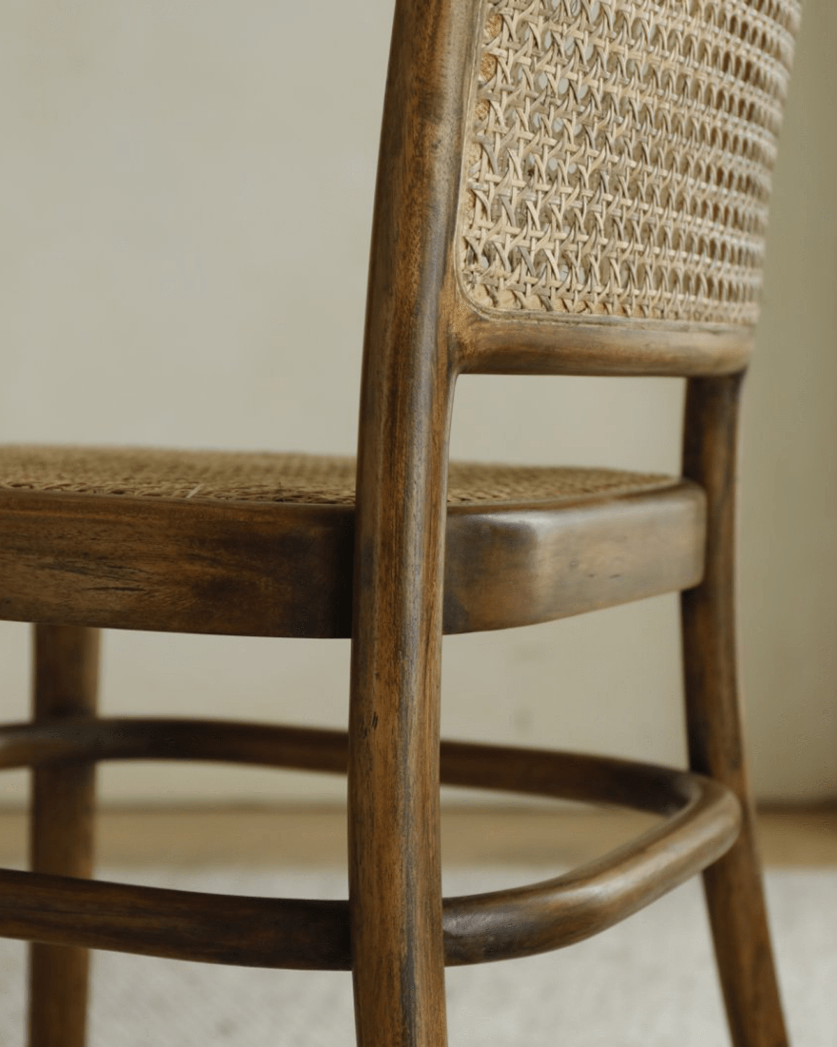 NO.811 Chair detail: Teak frame with natural rattan weaving. Close-up of curved back and seat.
