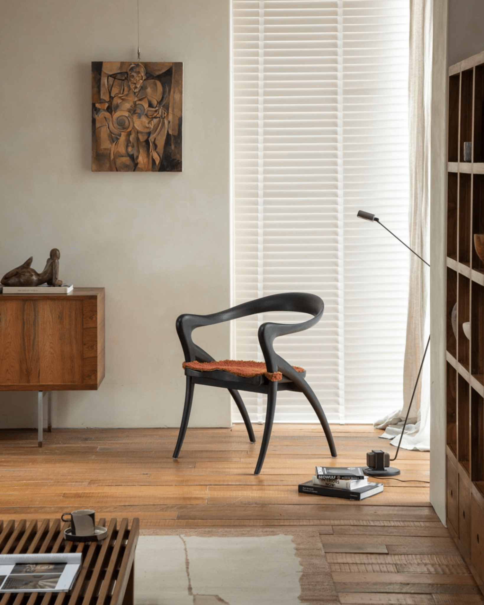 Black Olivia Chair in modern interior with teak wood and orange cushion, modern design