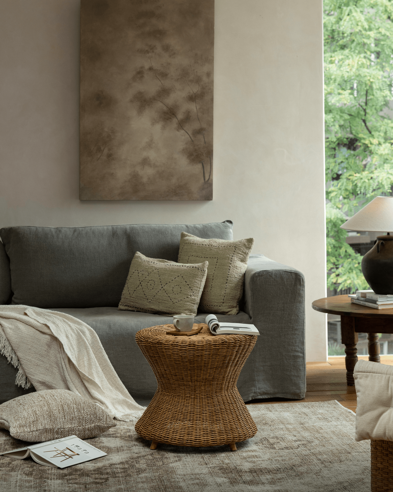 Bongo Rattan Side Table, a woven hourglass-shaped rattan accent table in a chic living room.