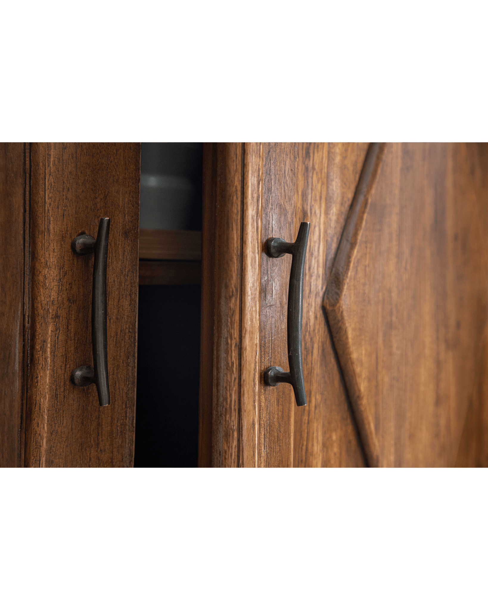 Victoria Teak Cabinet detail: hand-carved door, rustic dark metal pull handle.