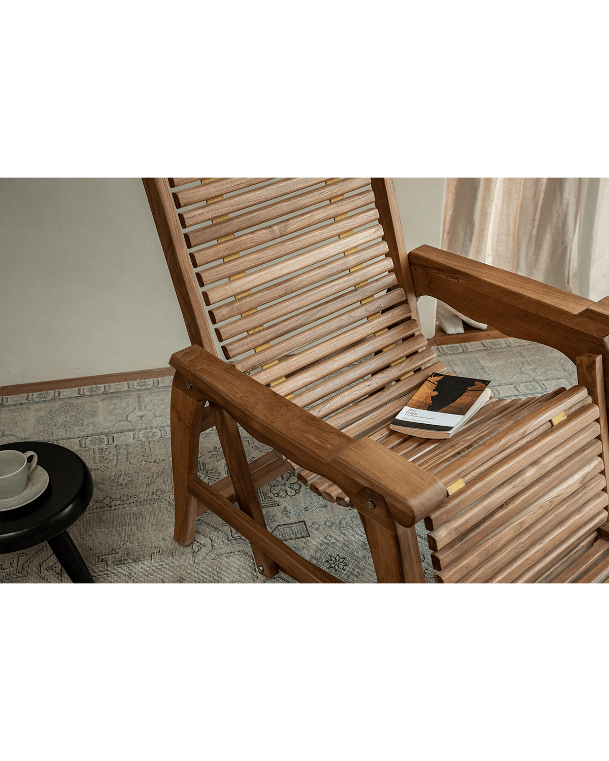 Teak Roller Chaise Lounge Chair with book, showcasing the wood grain and design for full-body support