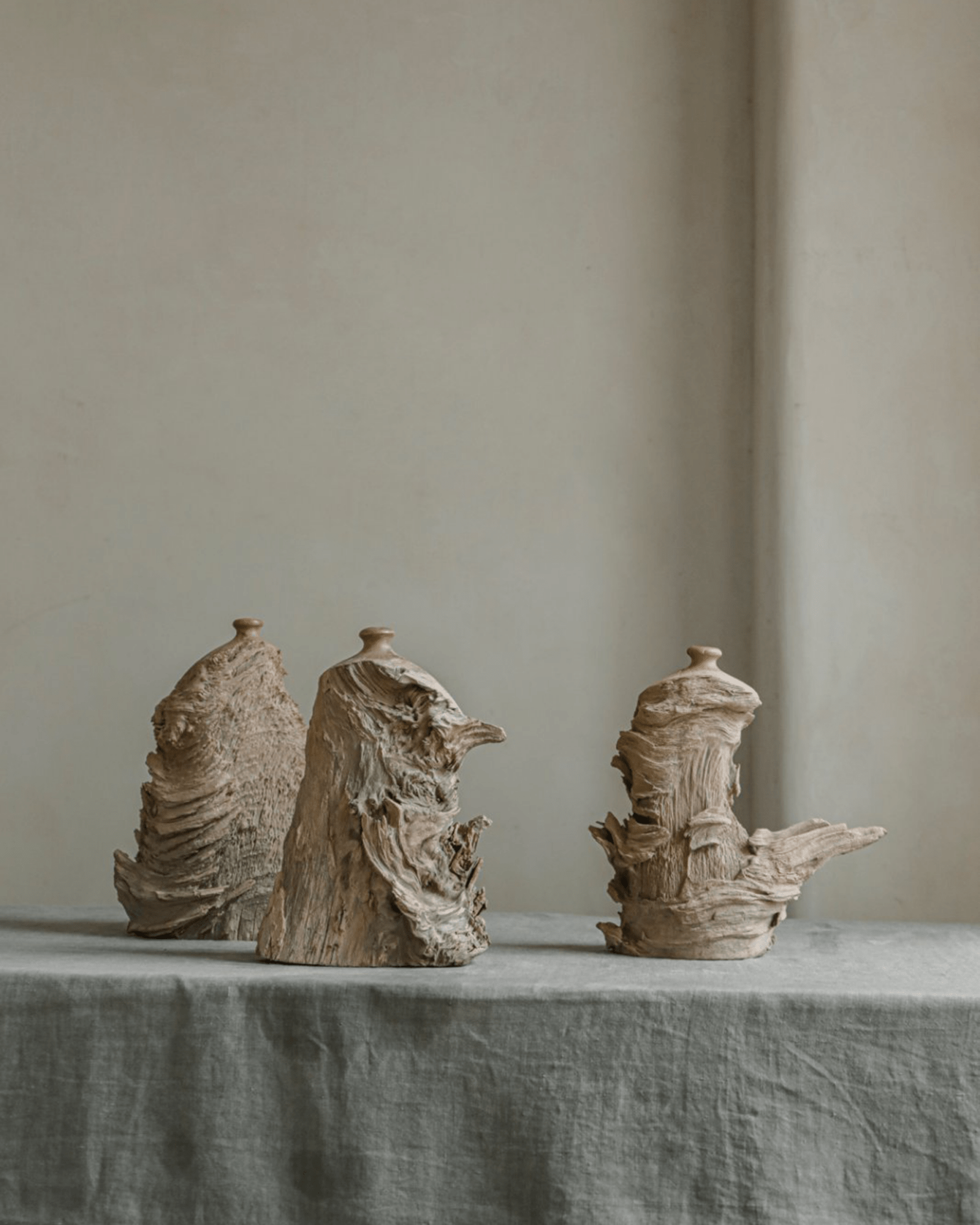 Wavy wooden vases, handcrafted and perfect for home decor, displayed on gray table