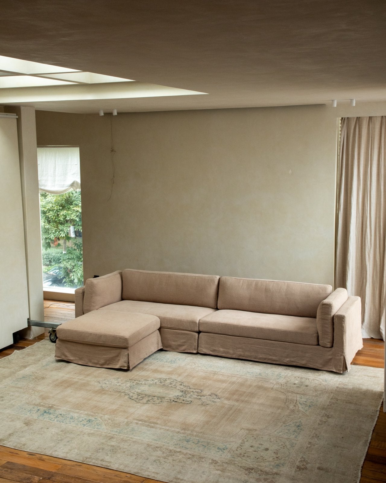 Beige linen skirt sectional sofa in modern living room, modular design and relaxed atmosphere