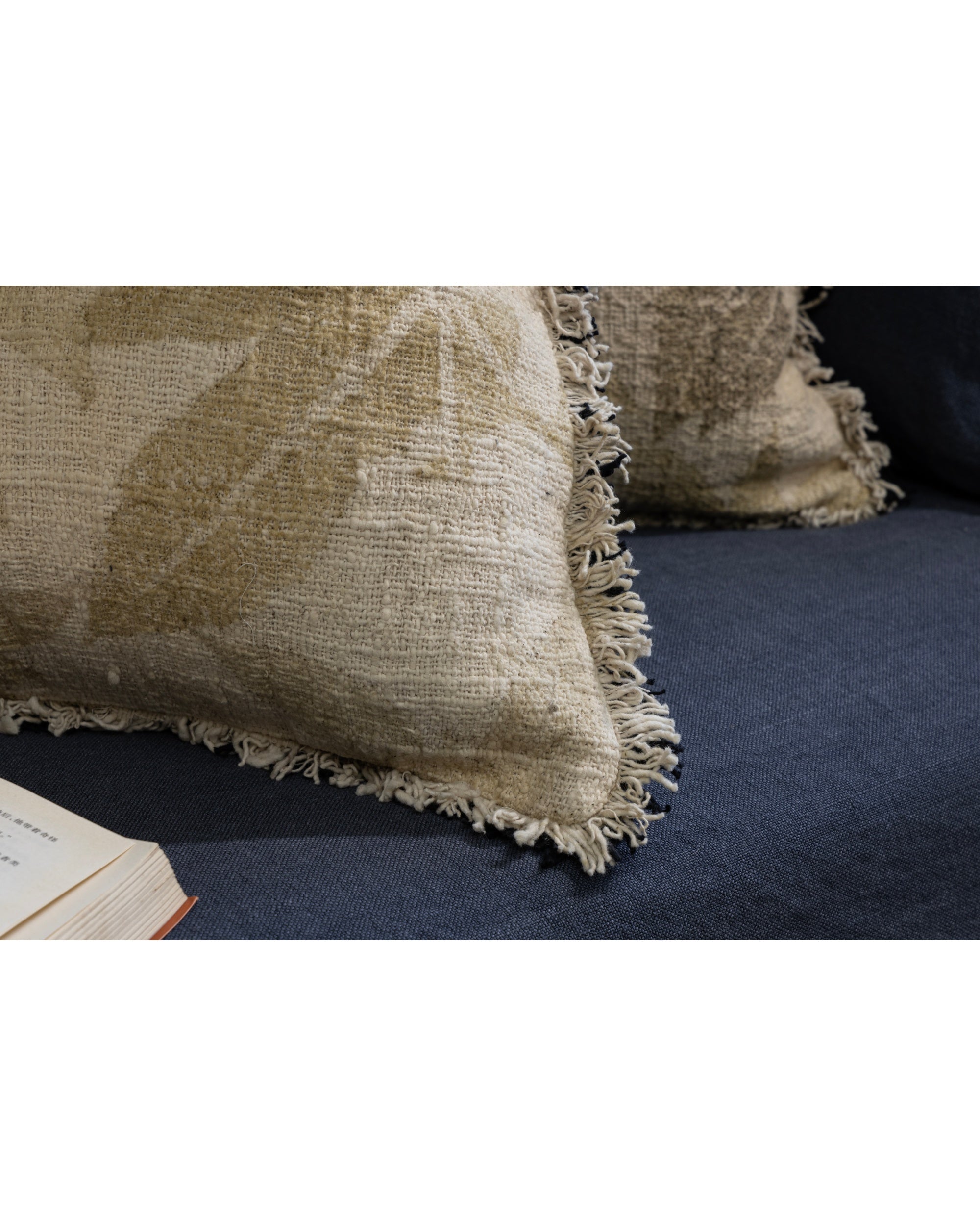 Verda Pillow in textured beige cotton with a faded plant print and fringe detail.