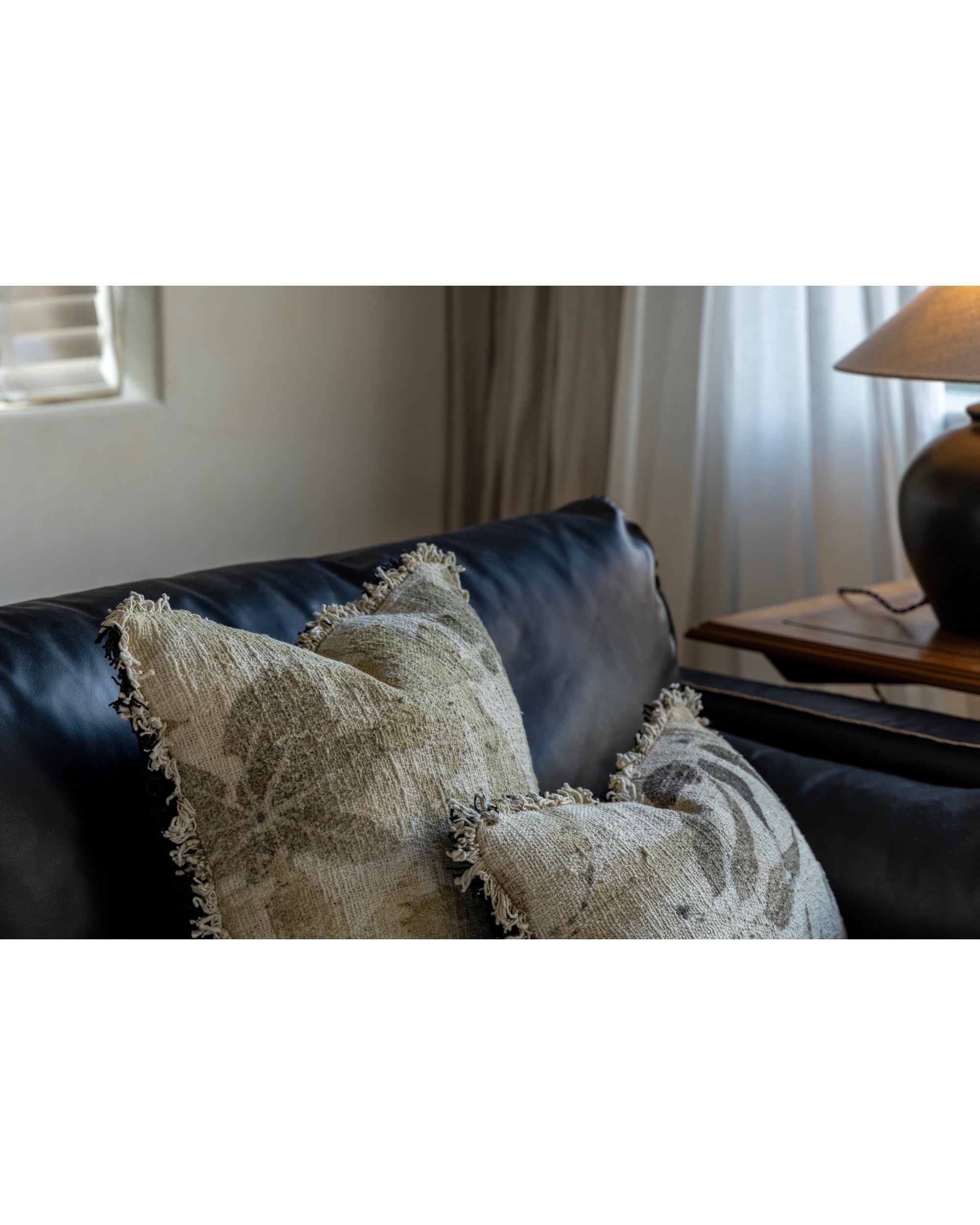 Verda Pillow: hand-crocheted cotton with plant print and fringe on sofa