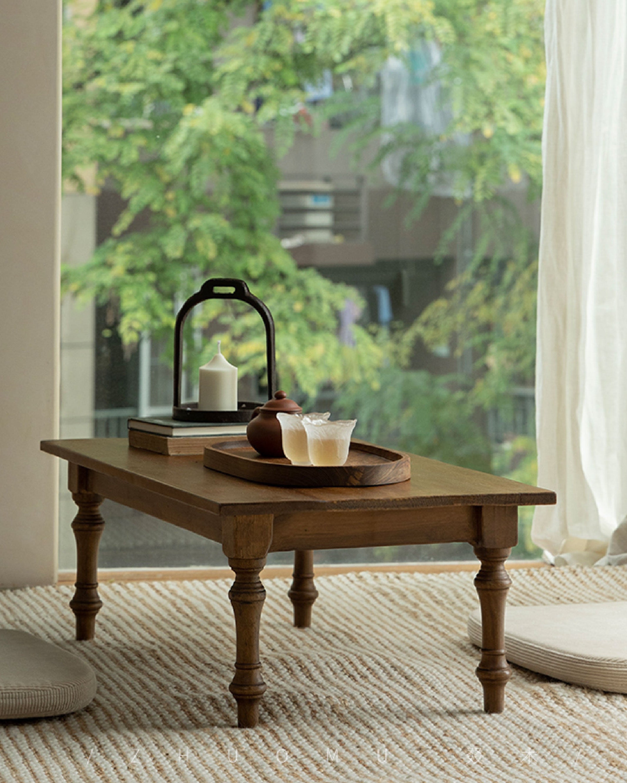 Reclaimed wood Tatami tea table with tea, candles, books, and a serene natural setting for tea time