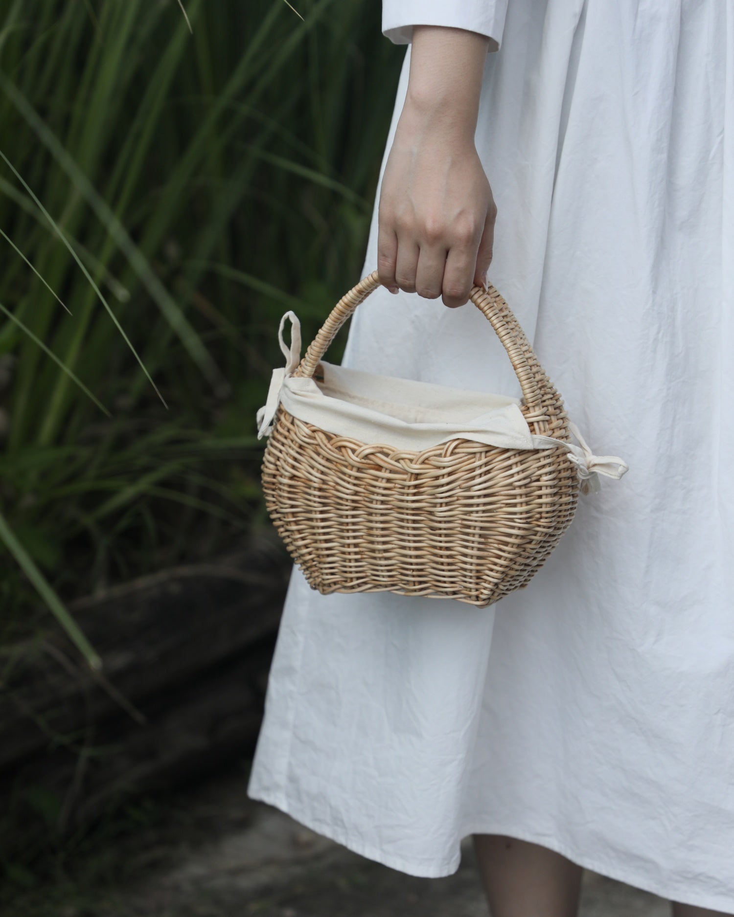 Nora Clutch woven rattan basket with tie detail and cotton lining.
