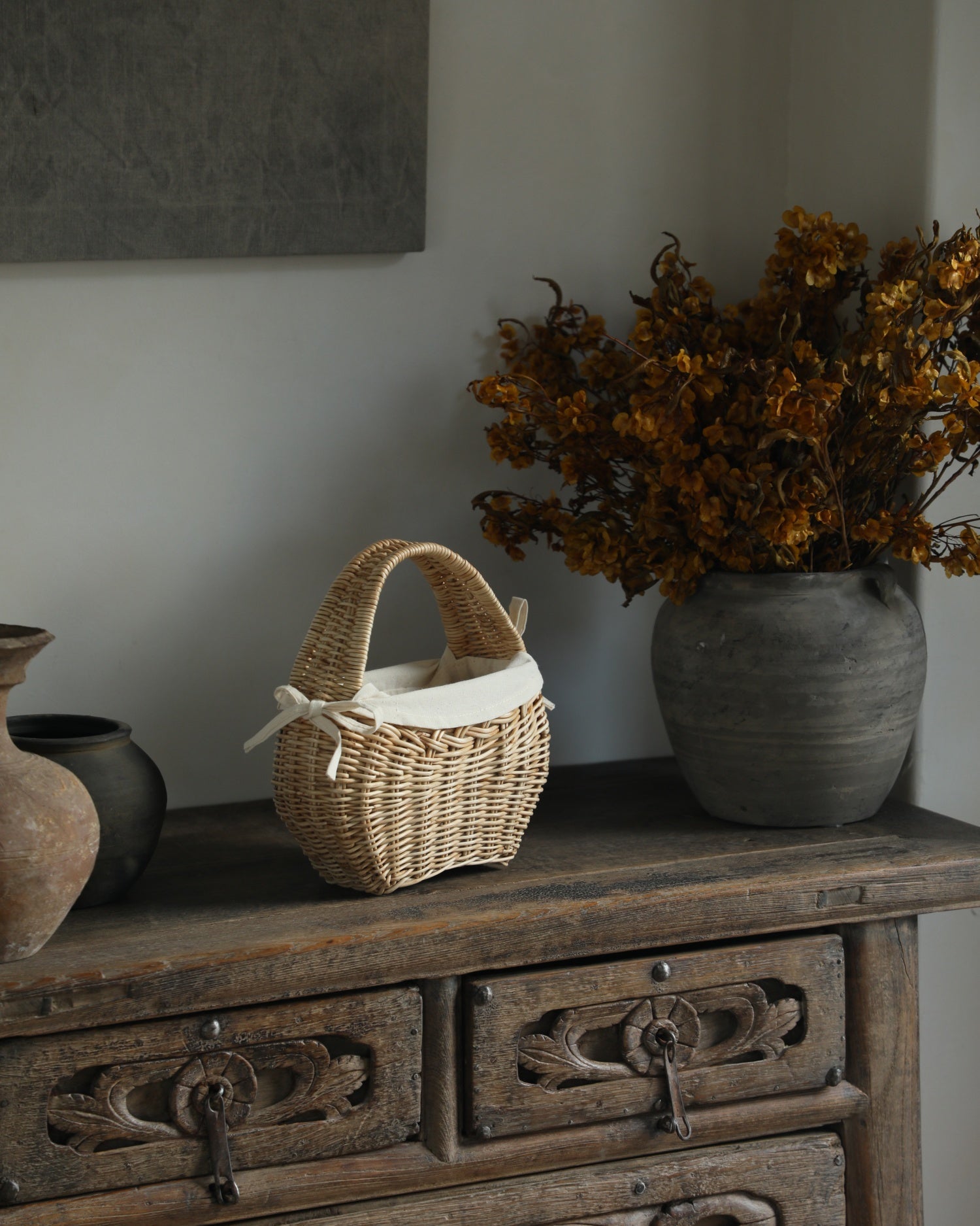 Nora Clutch finely woven rattan basket with bow tie detail and white lining.