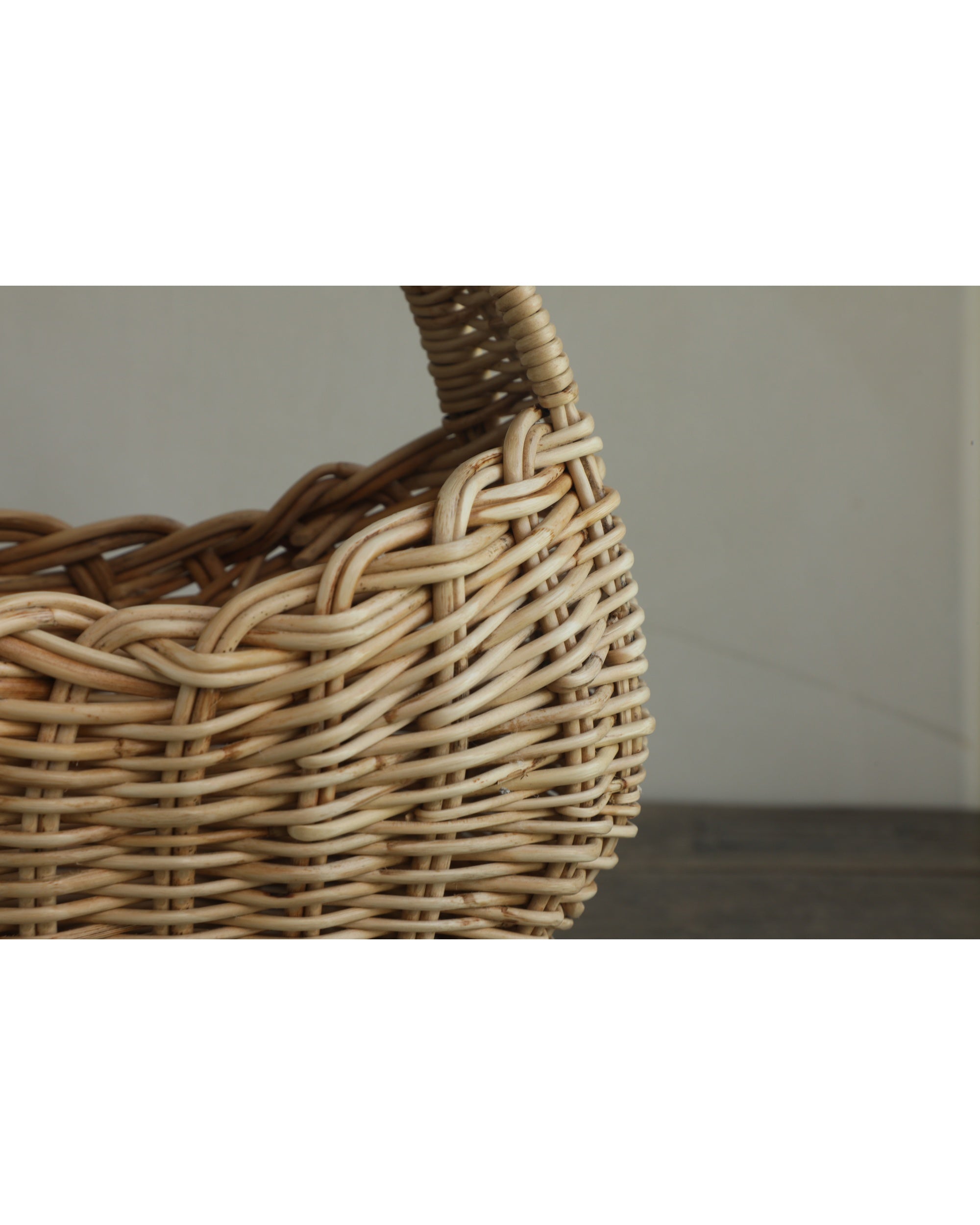 Nora Clutch: Woven rattan storage basket with textured finish.