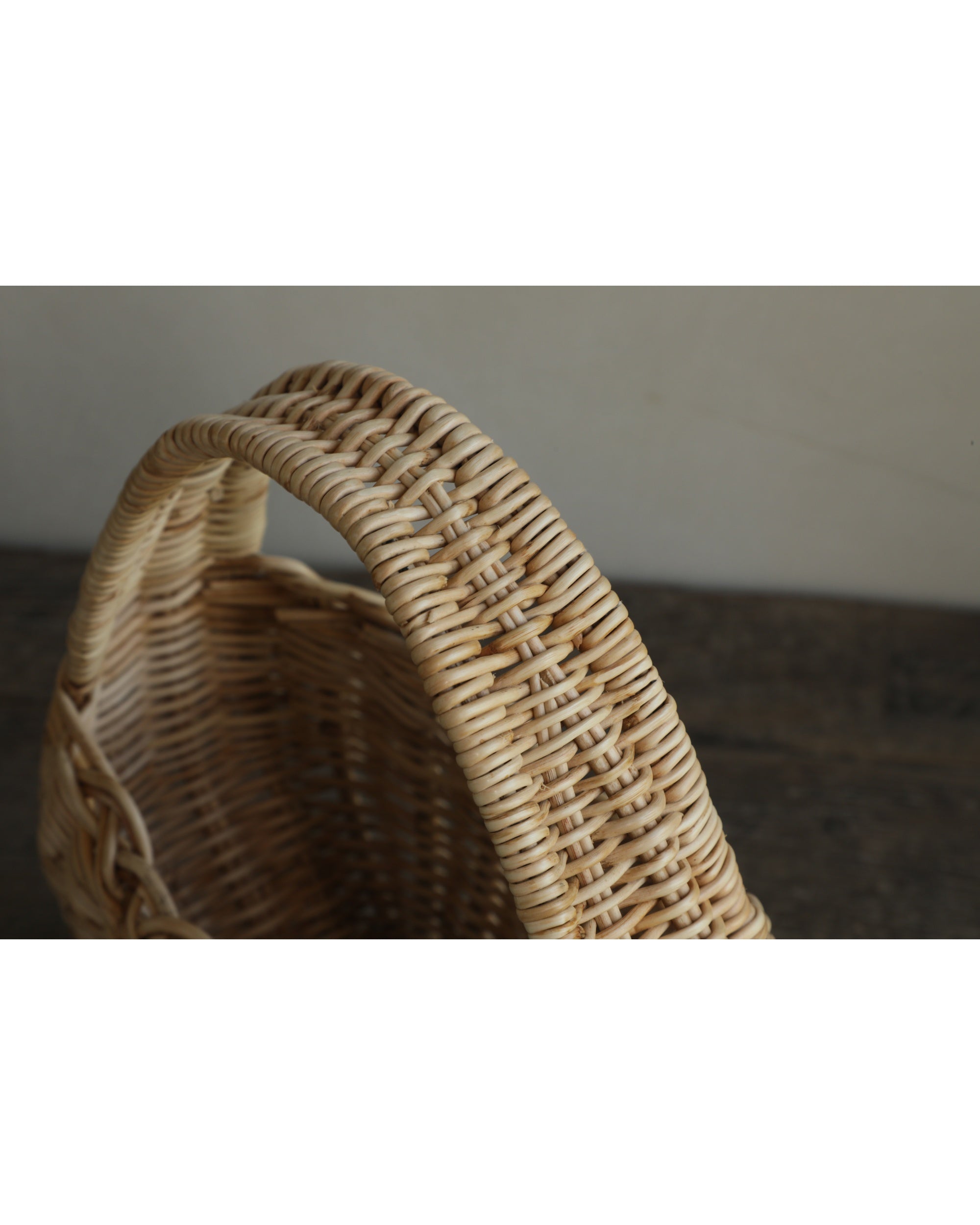 Nora Clutch woven rattan basket with detailed handle and natural texture.