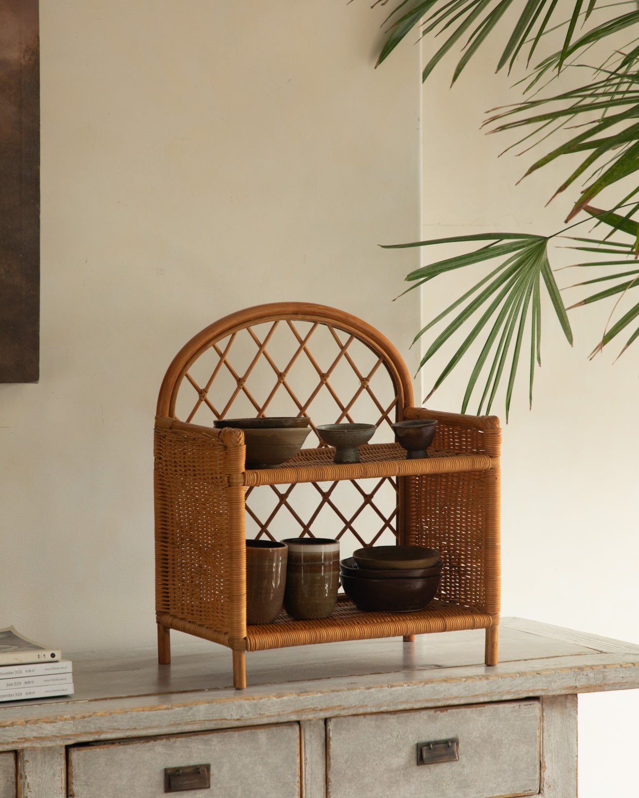 Solana Stand made of woven rattan with arched top and two open shelves.