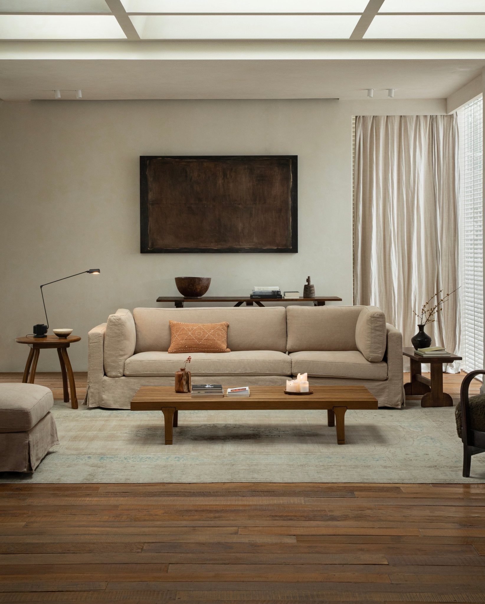 Beige Skirt Sectional Sofa in a modern living room, linen slipcover, wooden furniture.