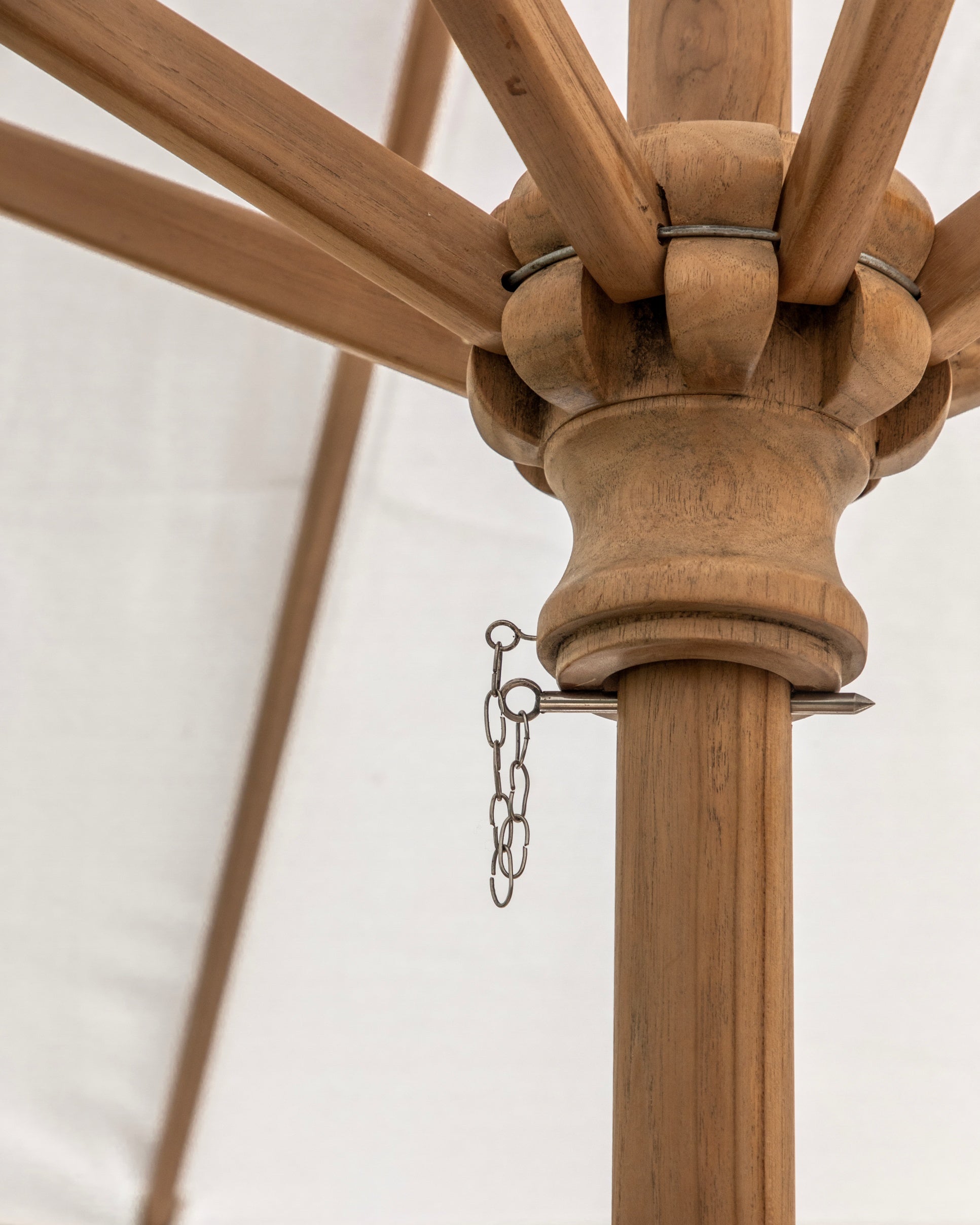 Close-up of a wooden ceiling fan with a chain on a white background