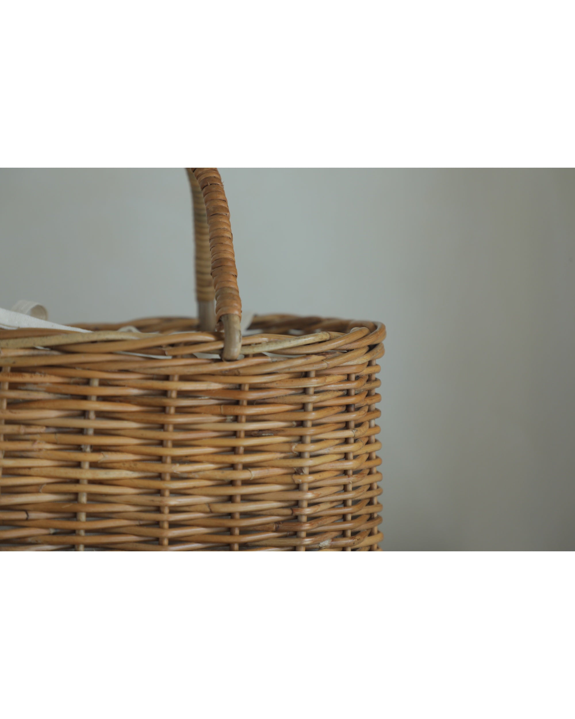 Close-up of a handmade natural rattan handbag with woven basket texture and arched handle